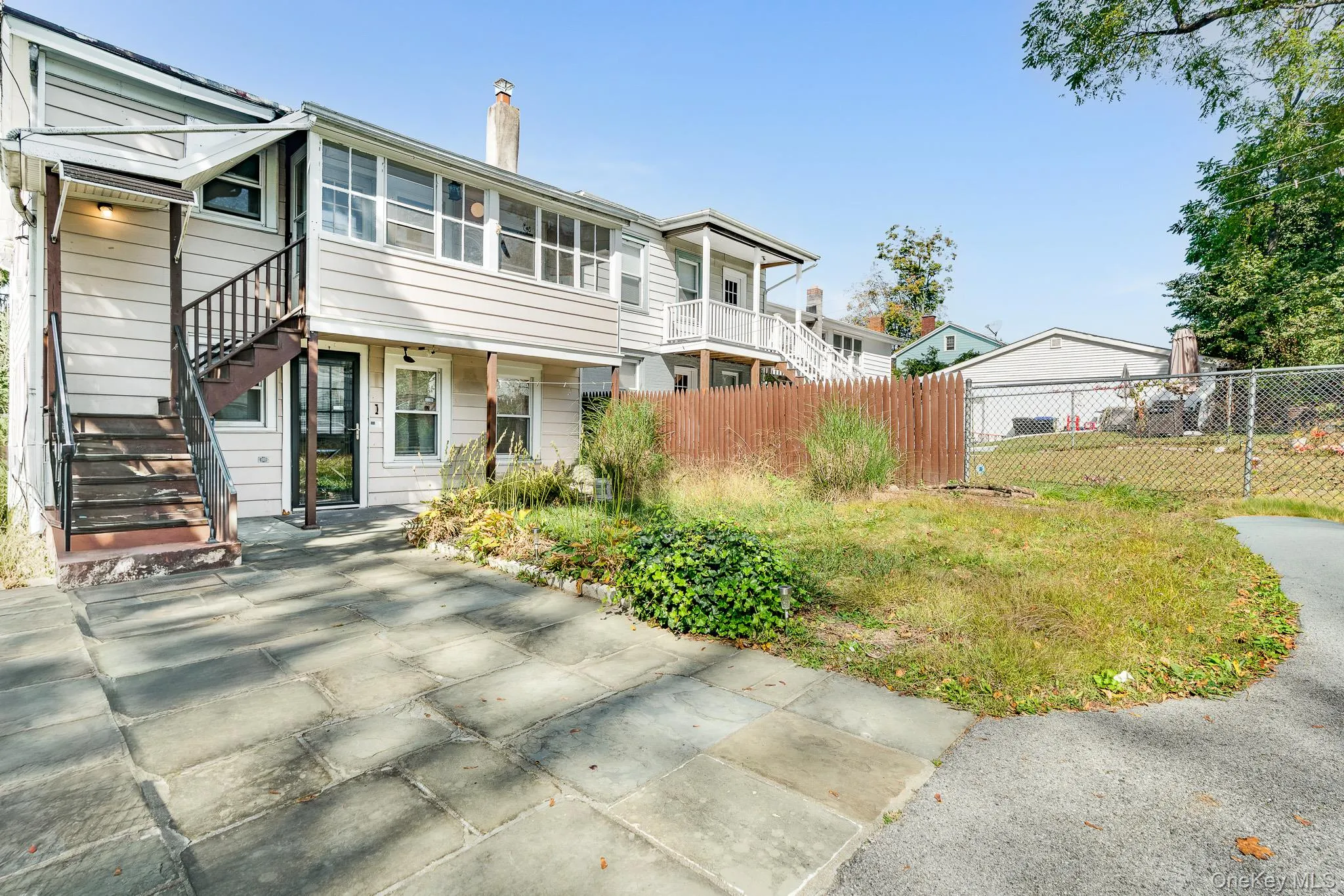 View of front of house with stairs, a chimney, and a patio area View of front of house with stairs, a chimney, and a patio area
