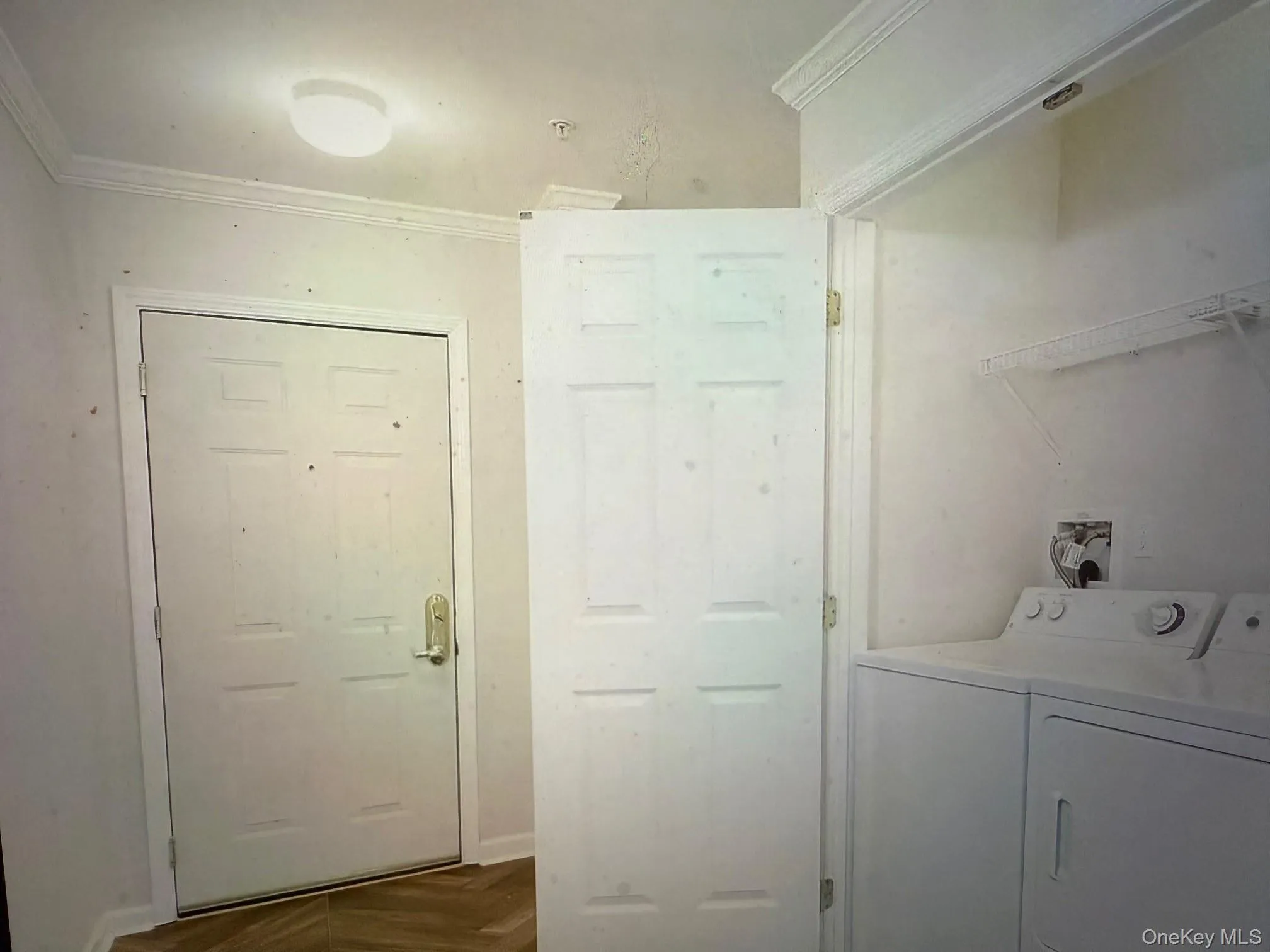 Laundry room featuring washing machine and dryer and crown molding Laundry room featuring washing machine and dryer and crown molding