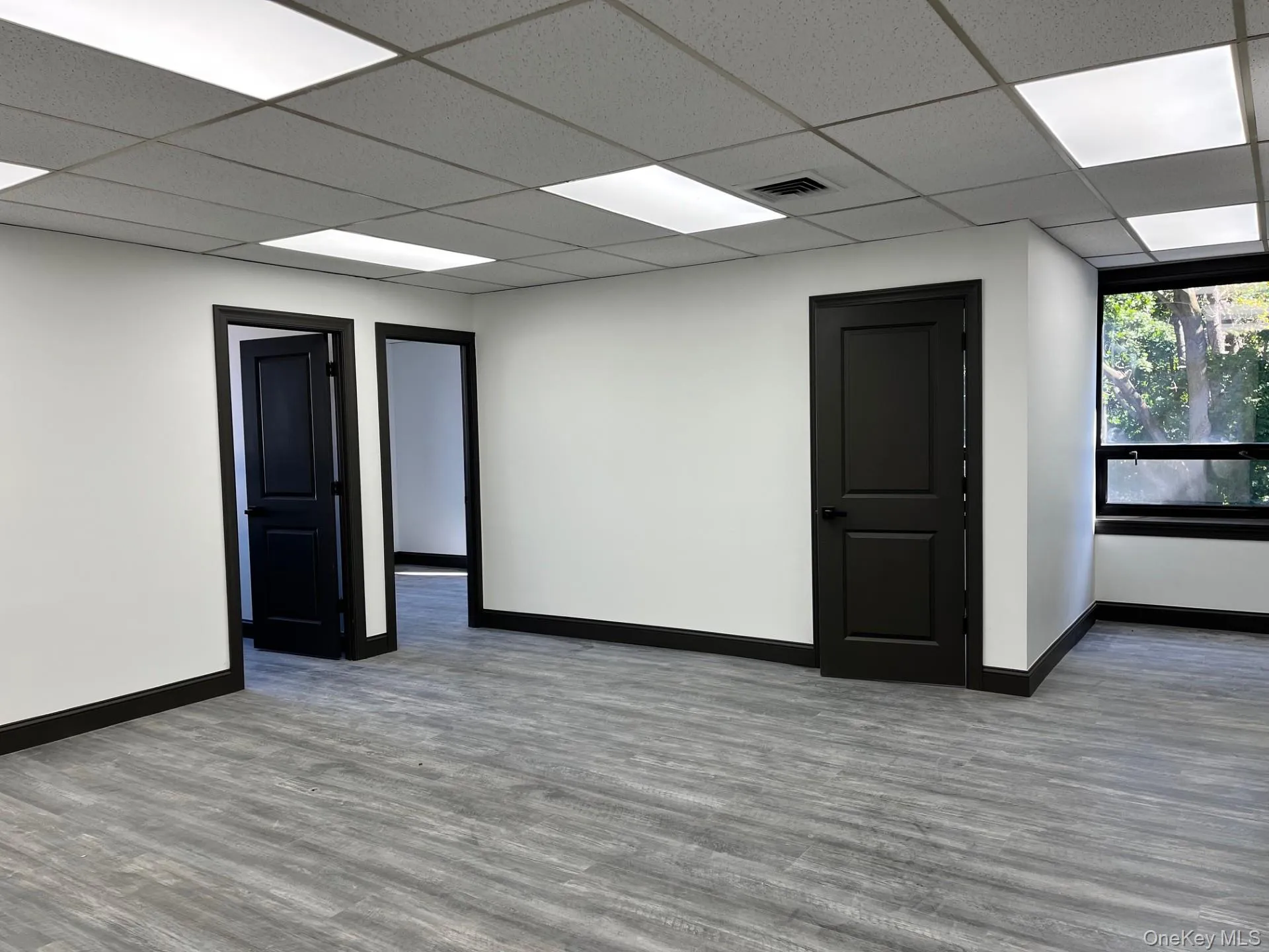 Spare room with wood finished floors and a drop ceiling Spare room with wood finished floors and a drop ceiling