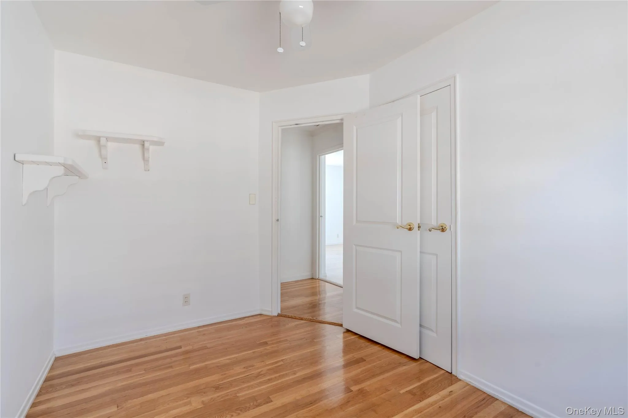 Empty room featuring light wood-type flooring and a ceiling fan Empty room featuring light wood-type flooring and a ceiling fan