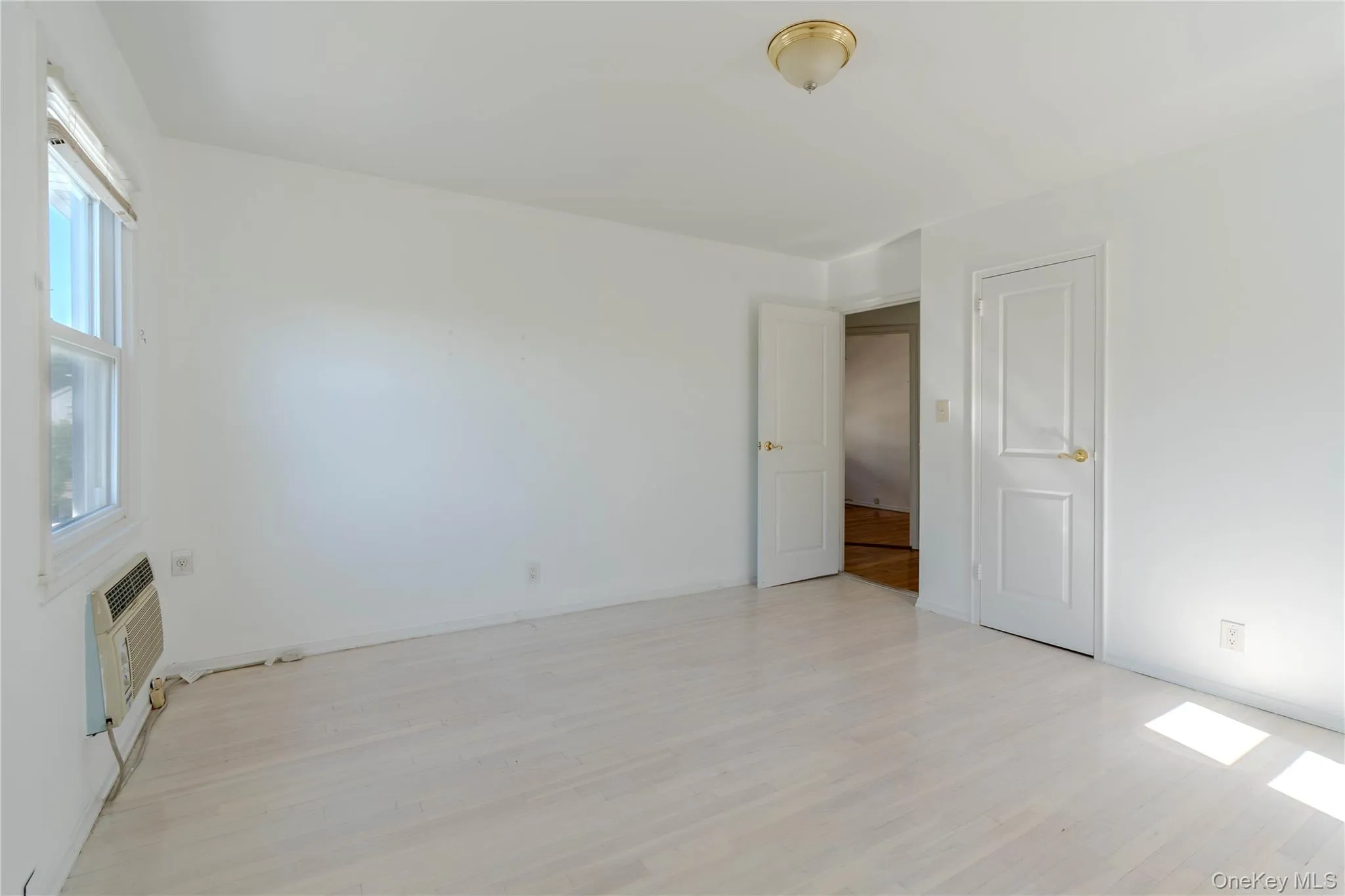 Spare room with light wood-type flooring and a wall mounted AC Spare room with light wood-type flooring and a wall mounted AC