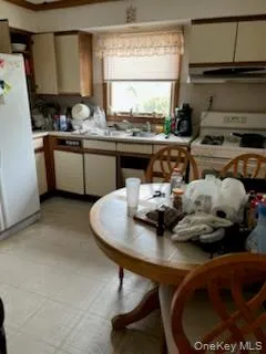 Kitchen featuring light countertops, white appliances, and range hood Kitchen featuring light countertops, white appliances, and range hood