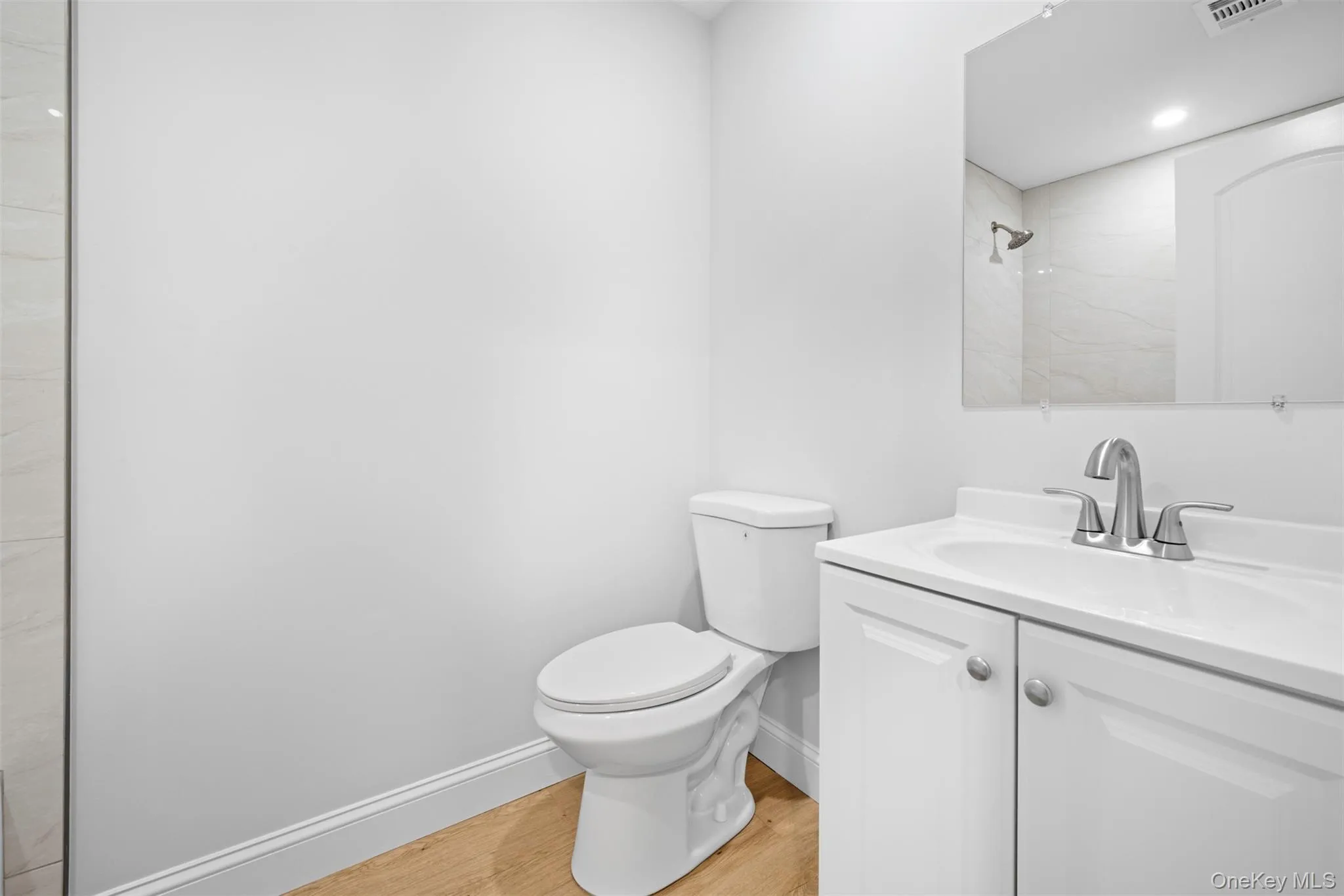 Bathroom with light wood finished floors, vanity, a shower, and recessed lighting Bathroom with light wood finished floors, vanity, a shower, and recessed lighting