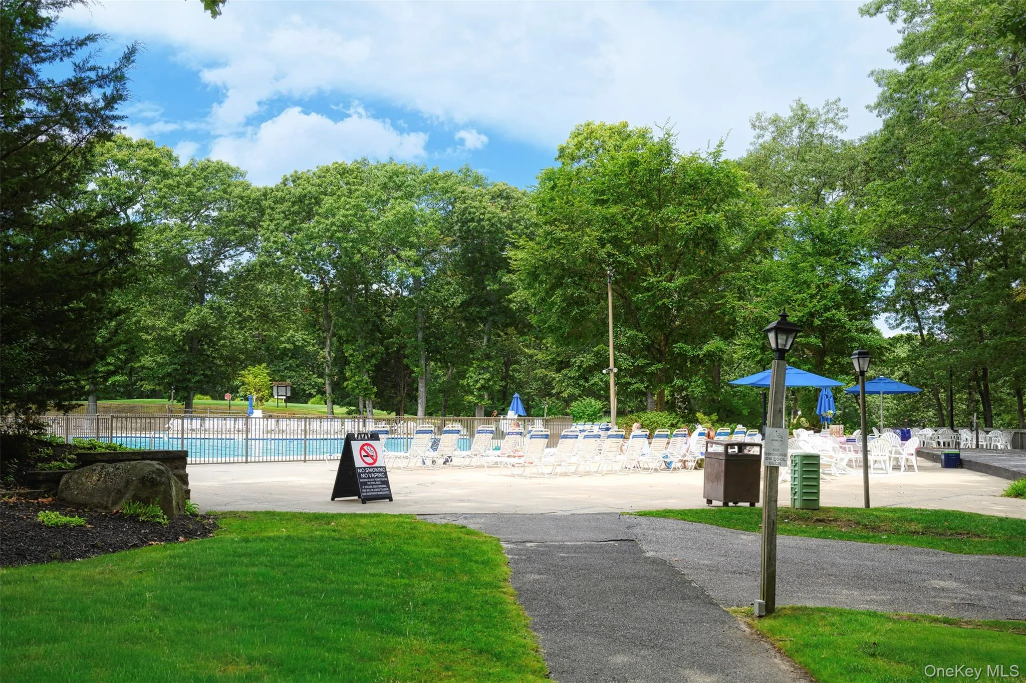 View of property's community with a pool and view of scattered trees View of property's community with a pool and view of scattered trees