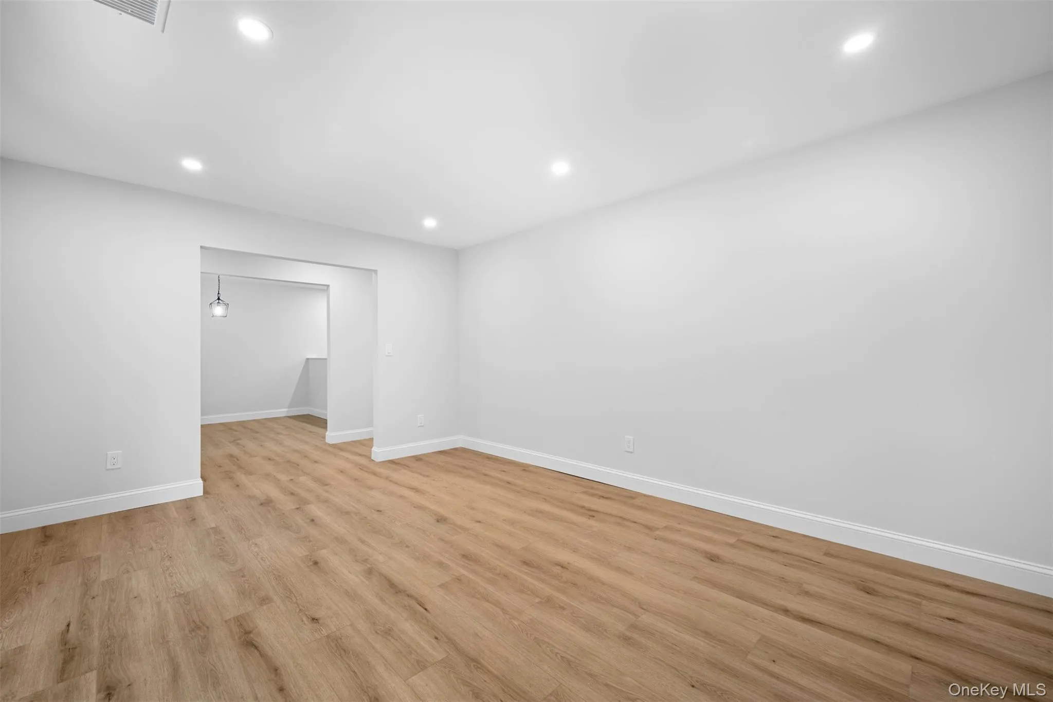 Empty room with light wood-type flooring and recessed lighting Empty room with light wood-type flooring and recessed lighting