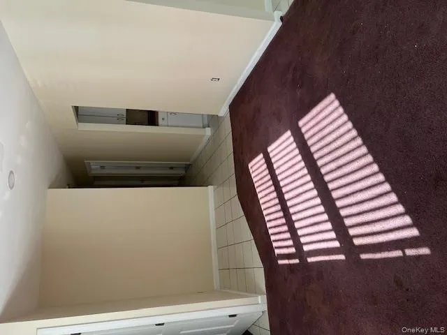 Empty room with light carpet and light tile patterned floors Empty room with light carpet and light tile patterned floors