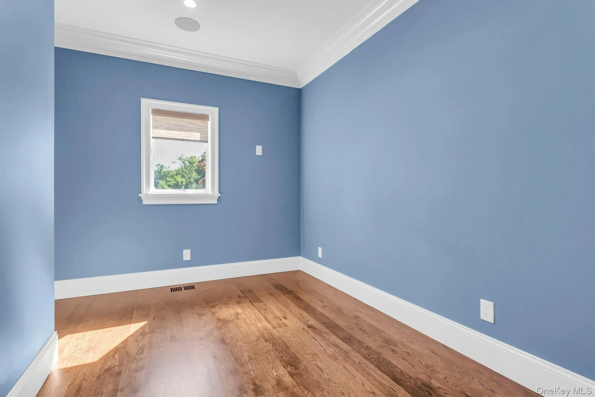 Empty room with ornamental molding and wood finished floors Empty room with ornamental molding and wood finished floors