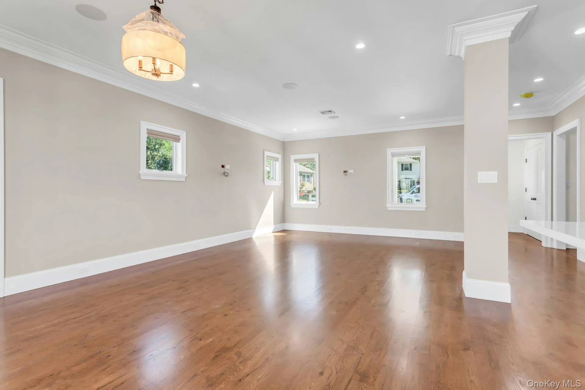 Empty room featuring crown molding, dark wood-type flooring, and recessed lighting Empty room featuring crown molding, dark wood-type flooring, and recessed lighting