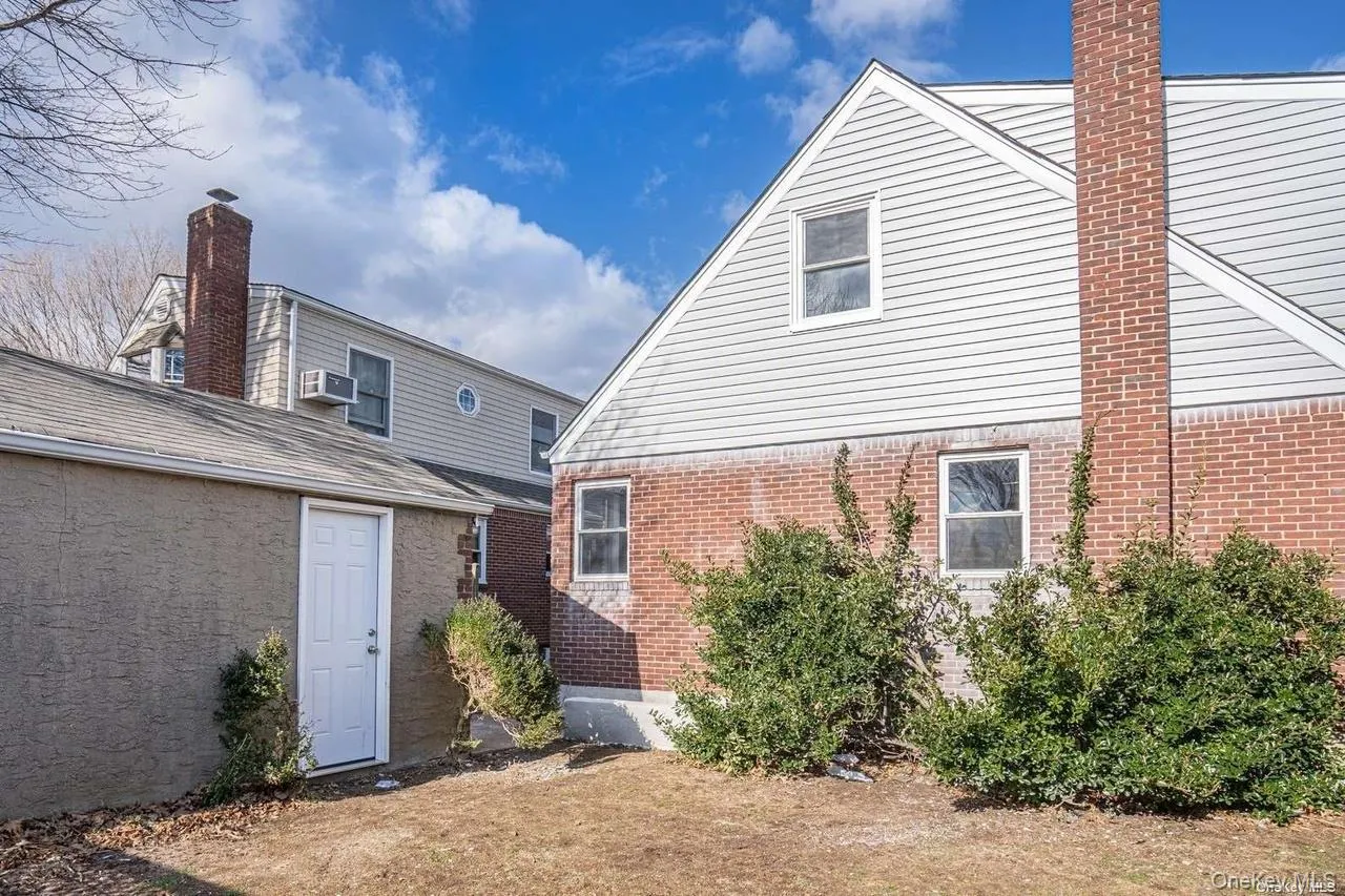 Back of property featuring brick siding Back of property featuring brick siding