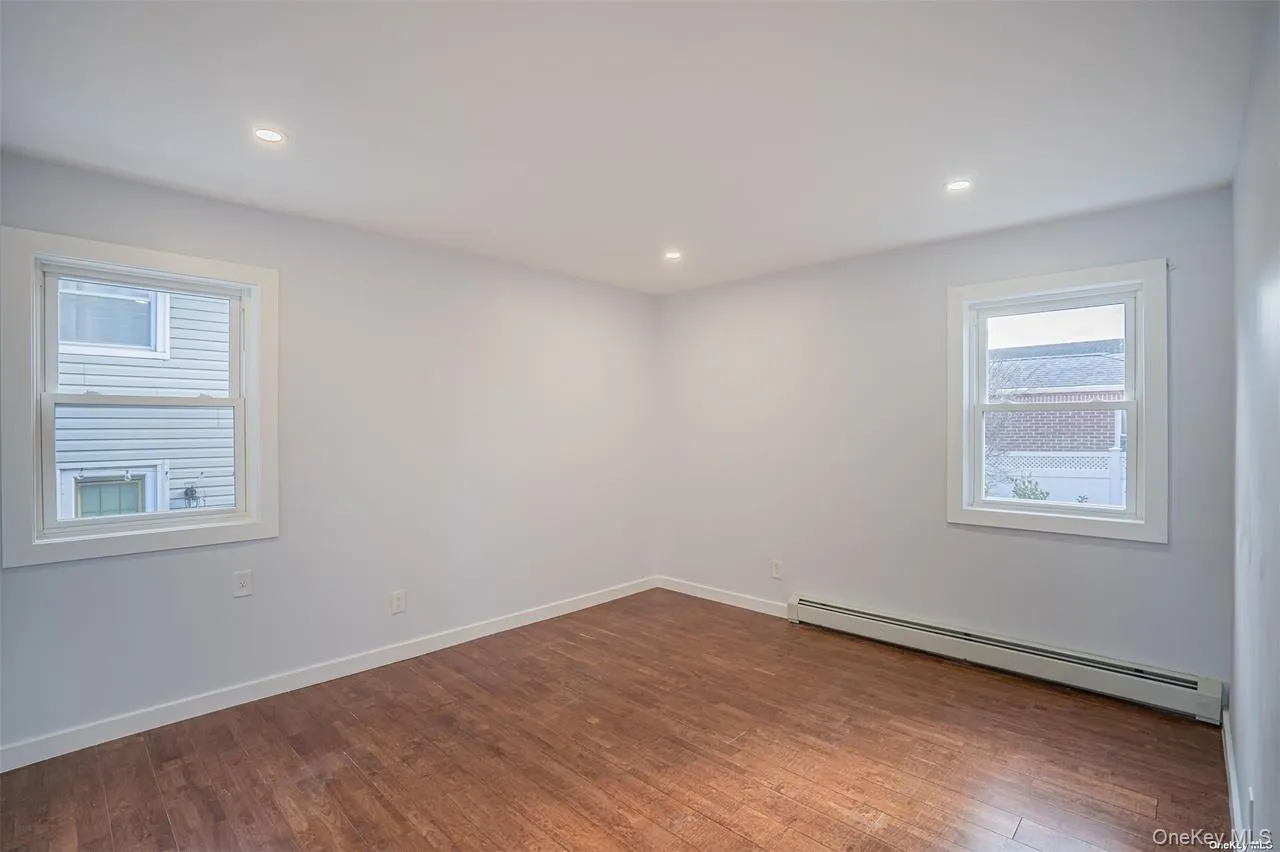 Spare room featuring a baseboard heating unit, dark wood-style flooring, and recessed lighting Spare room featuring a baseboard heating unit, dark wood-style flooring, and recessed lighting