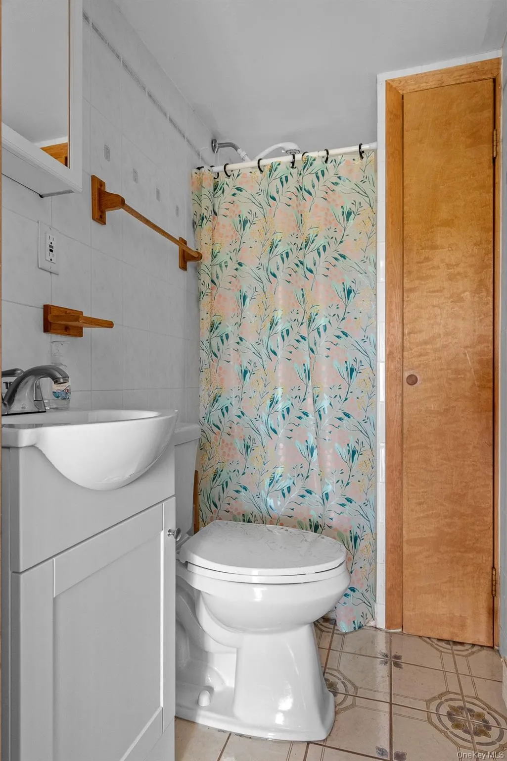 Full bath featuring tile walls, light tile patterned floors, and vanity Full bath featuring tile walls, light tile patterned floors, and vanity