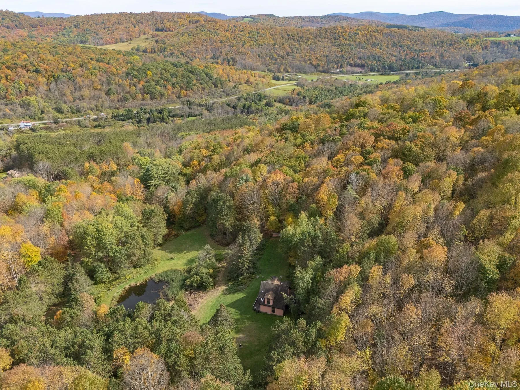 Aerial view of property and surrounding area with mountains and a heavily wooded area Aerial view of property and surrounding area with mountains and a heavily wooded area