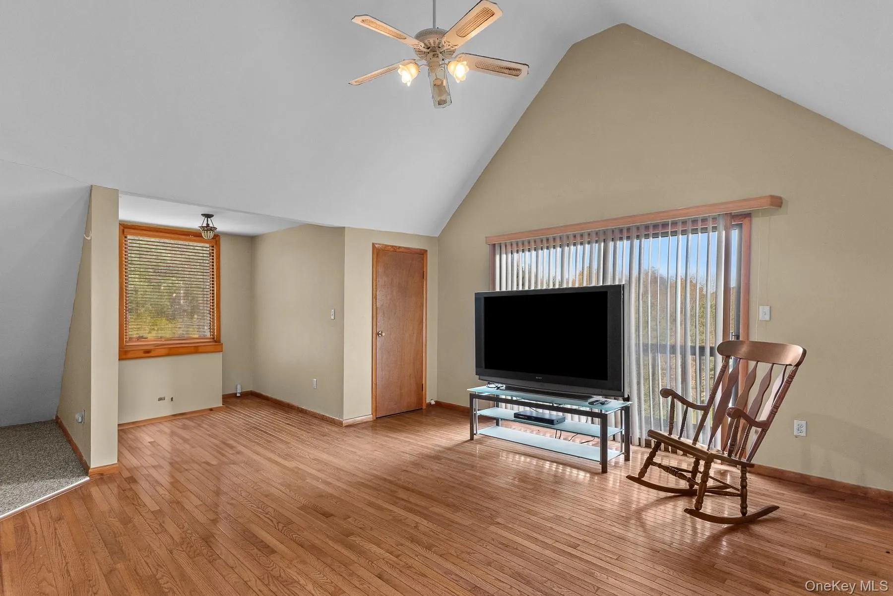 Living area featuring high vaulted ceiling, light wood-type flooring, and ceiling fan Living area featuring high vaulted ceiling, light wood-type flooring, and ceiling fan
