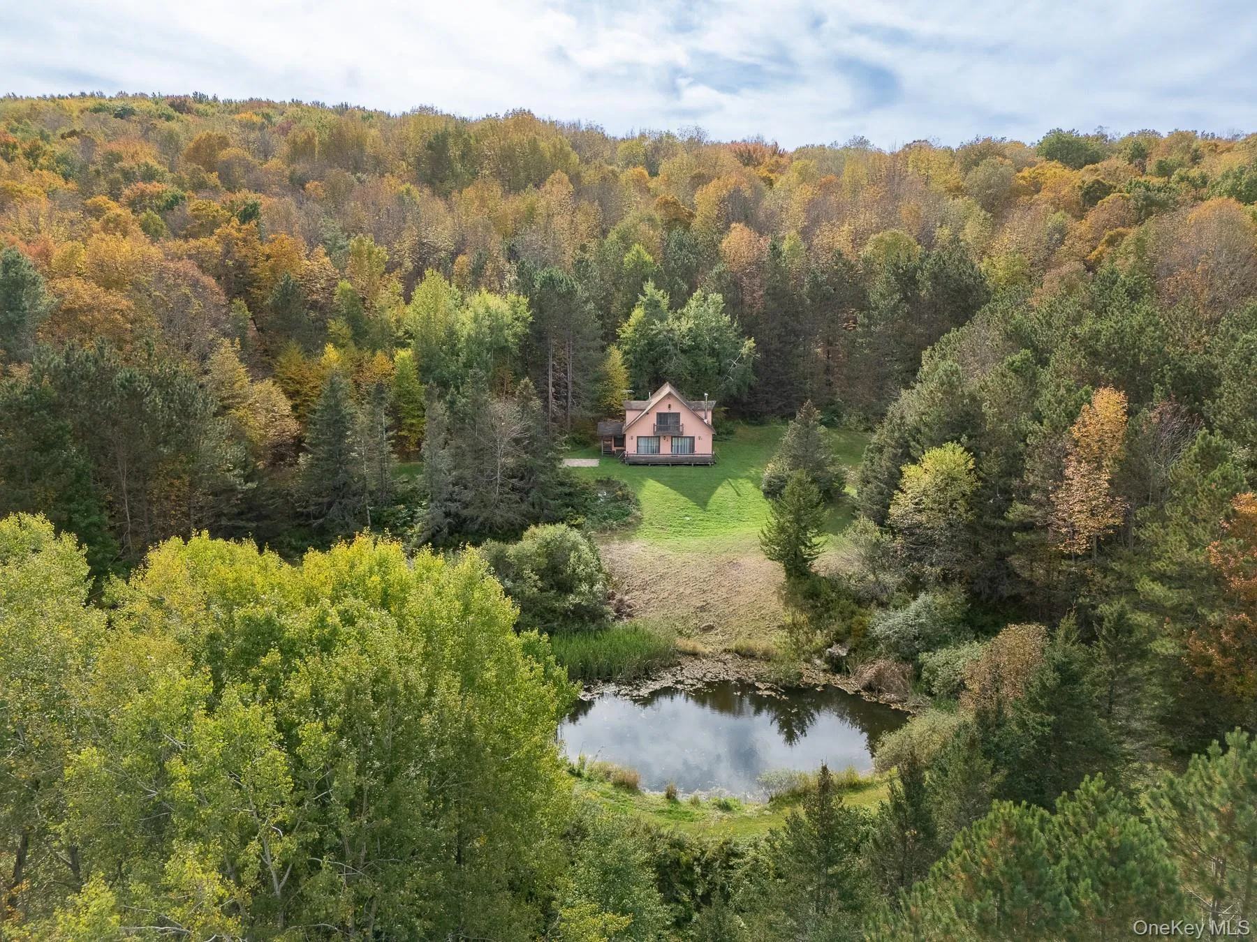 Aerial view of property and surrounding area featuring a nearby body of water and a forest Aerial view of property and surrounding area featuring a nearby body of water and a forest