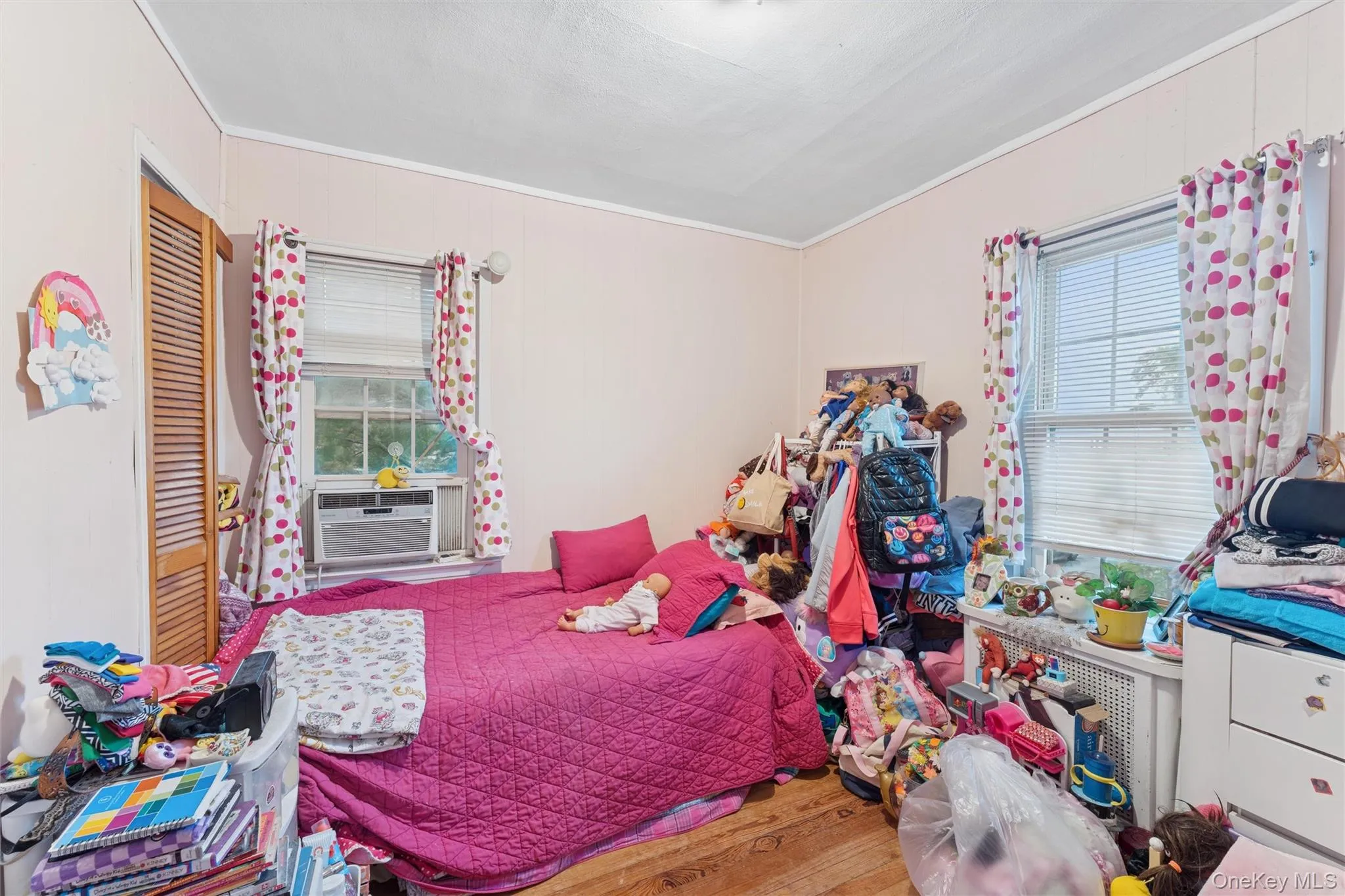 Bedroom featuring wood finished floors and ornamental molding Bedroom featuring wood finished floors and ornamental molding