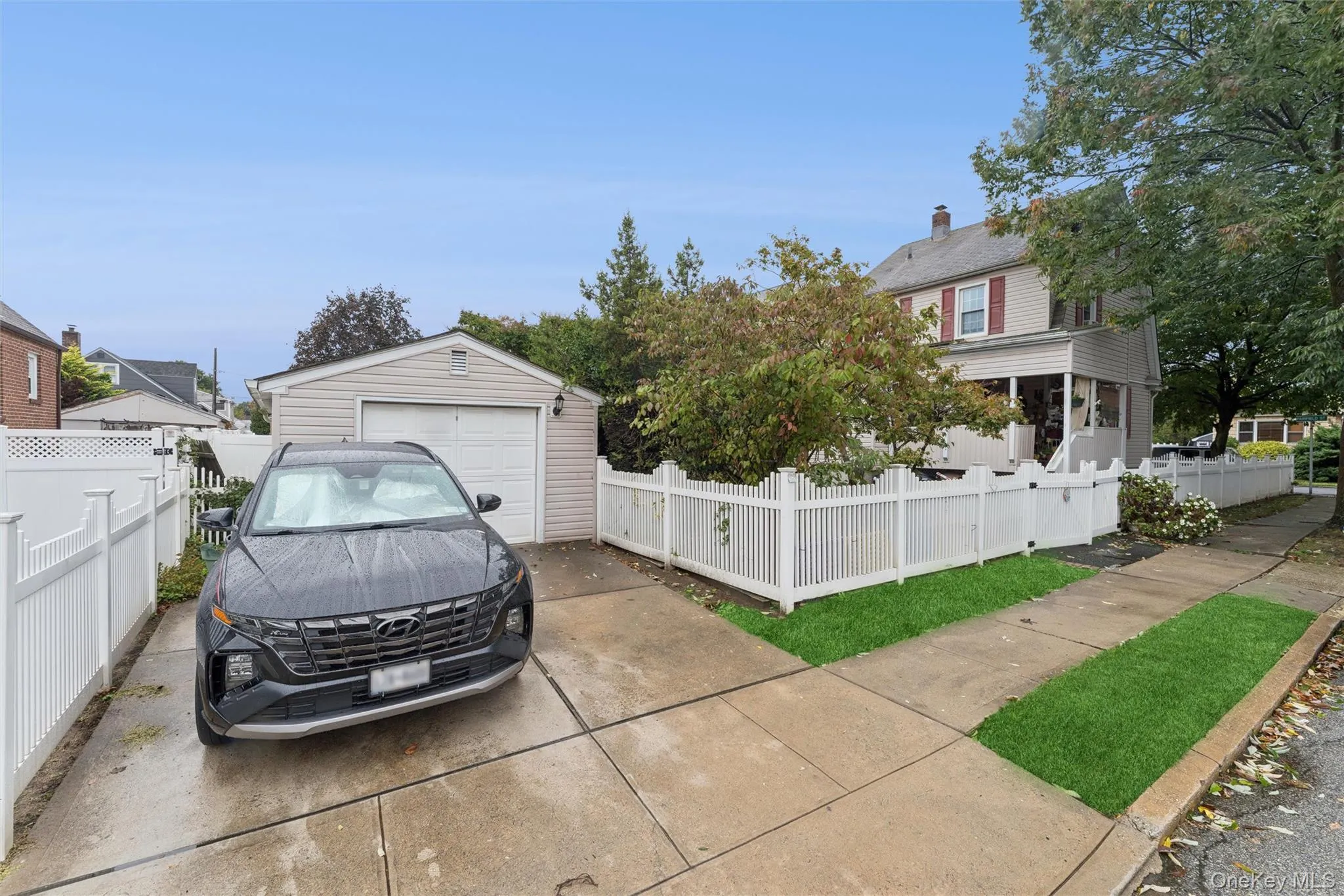 View of front of property featuring a fenced front yard, a detached garage, an outdoor structure, and driveway View of front of property featuring a fenced front yard, a detached garage, an outdoor structure, and driveway