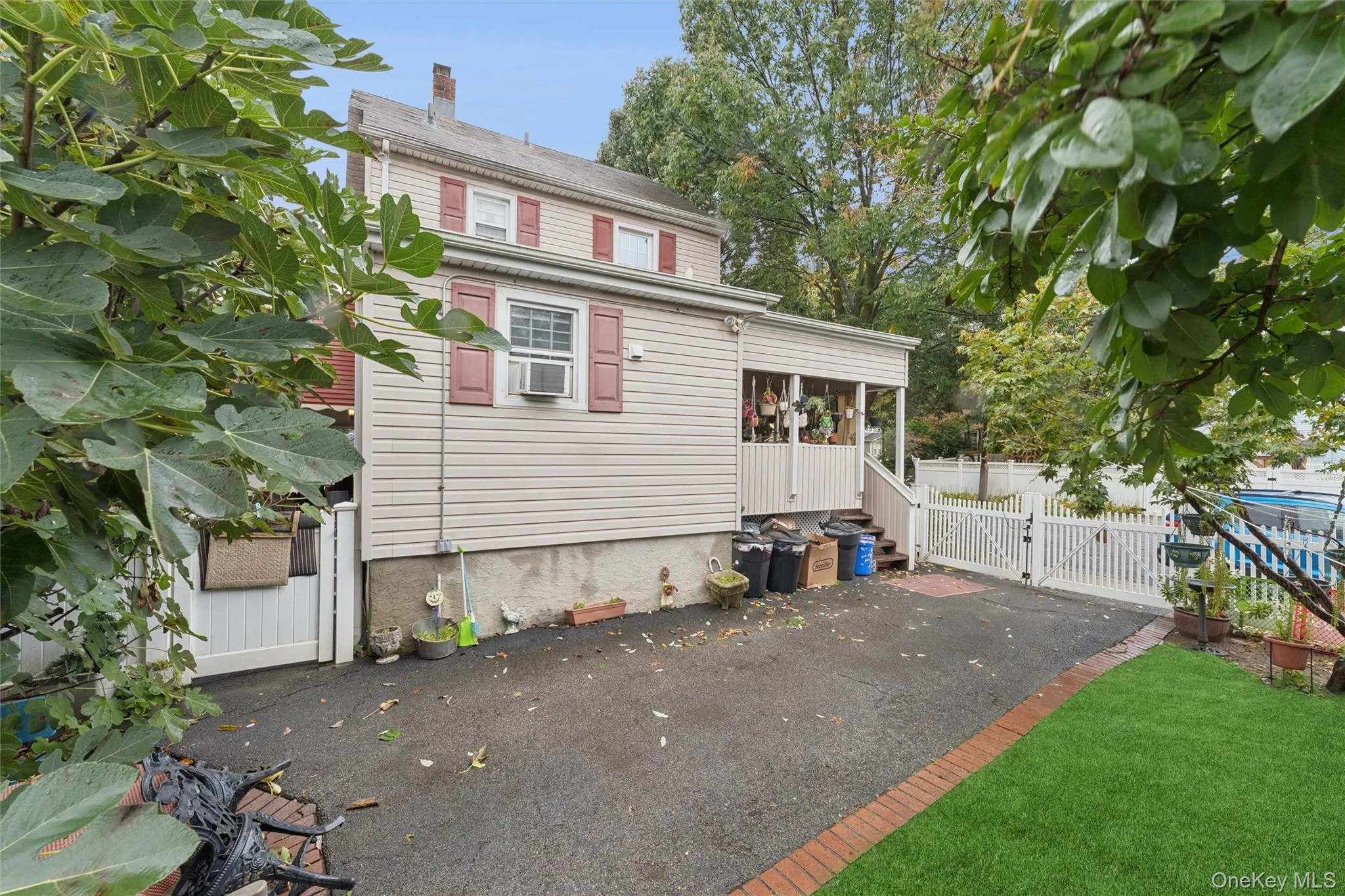 View of front facade with a gate, a patio, and a sunroom View of front facade with a gate, a patio, and a sunroom