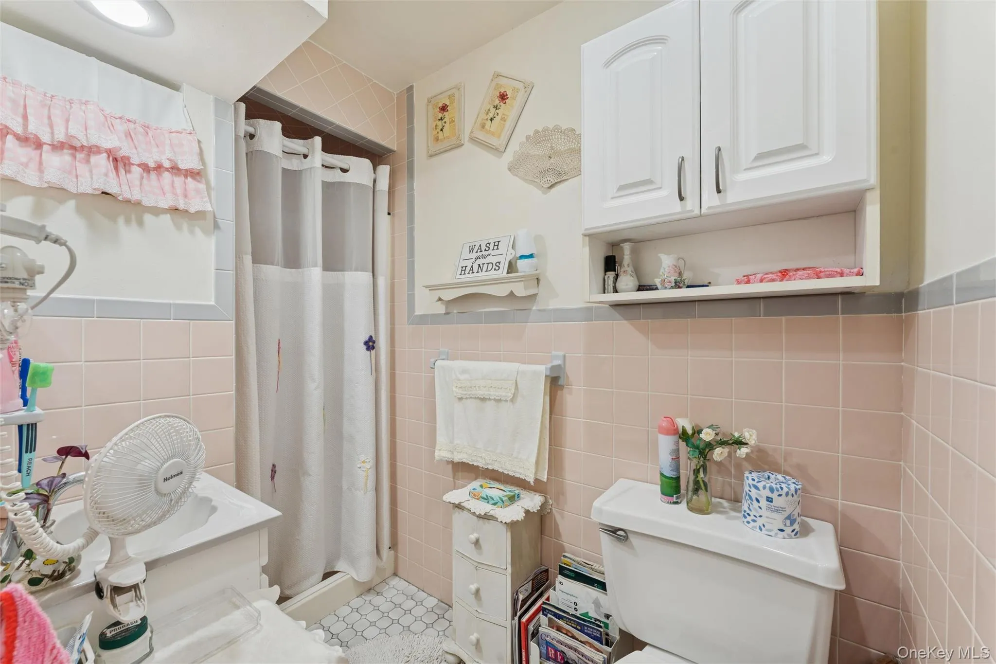 Bathroom featuring a stall shower, tile walls, and vanity Bathroom featuring a stall shower, tile walls, and vanity