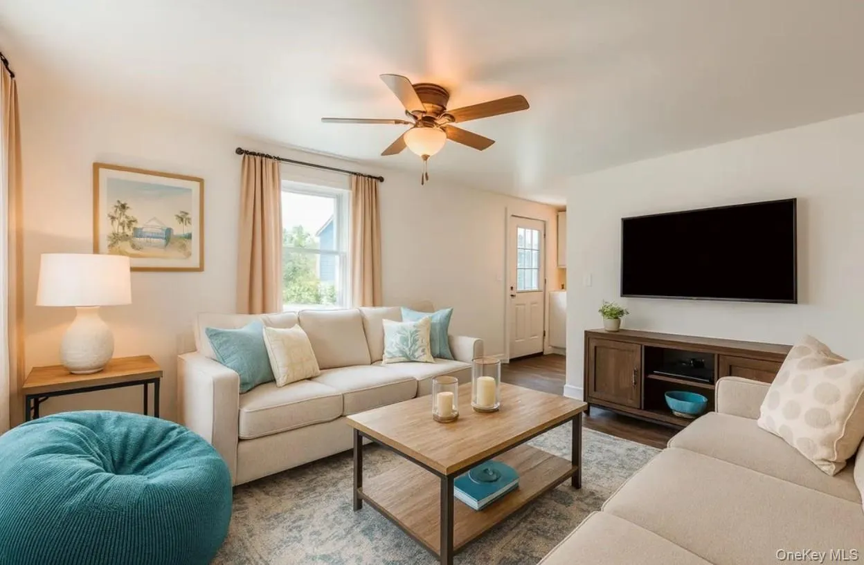 Living room featuring wood finished floors and a ceiling fan Living room featuring wood finished floors and a ceiling fan