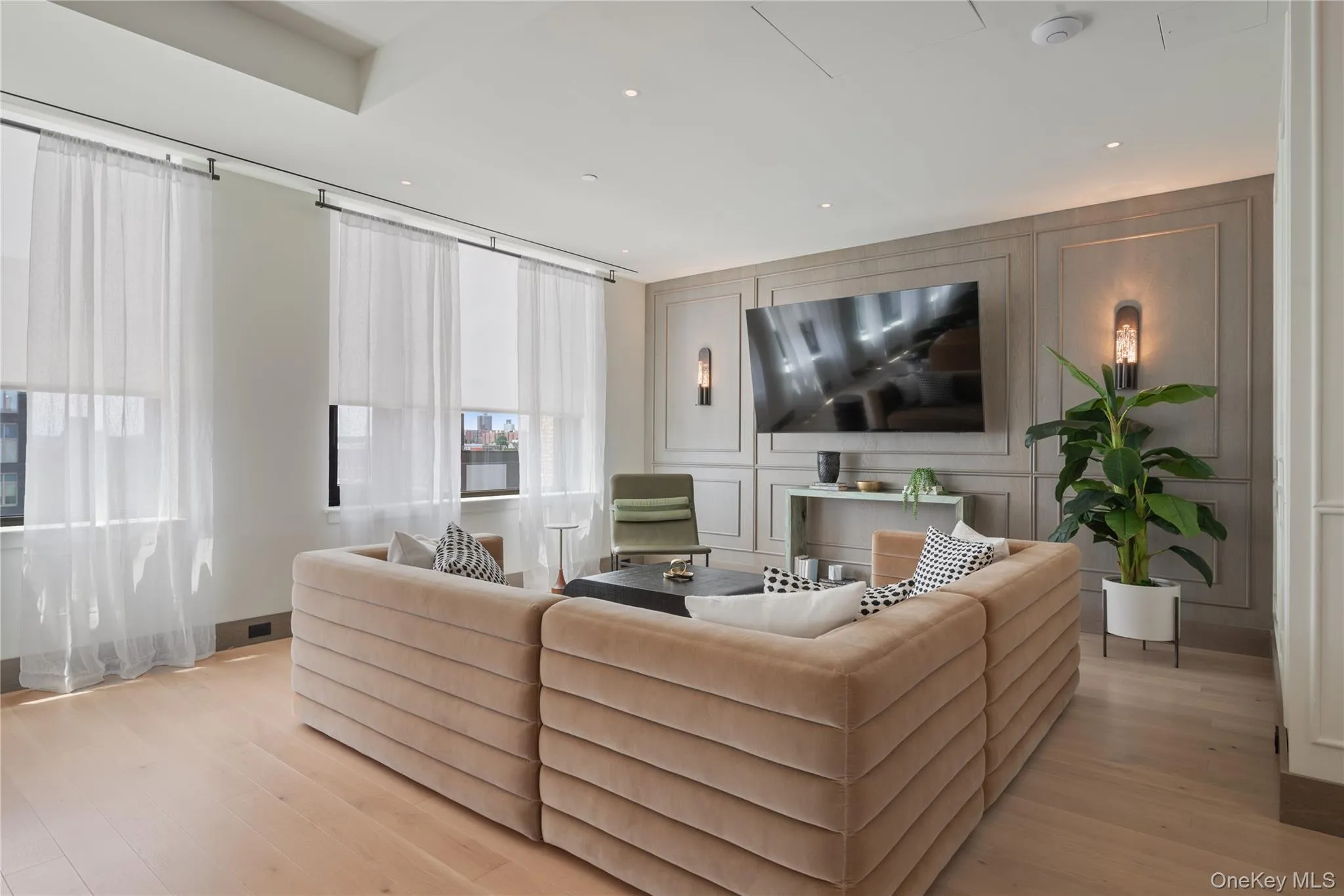 Living area with a decorative wall, light wood-type flooring, and recessed lighting Living area with a decorative wall, light wood-type flooring, and recessed lighting