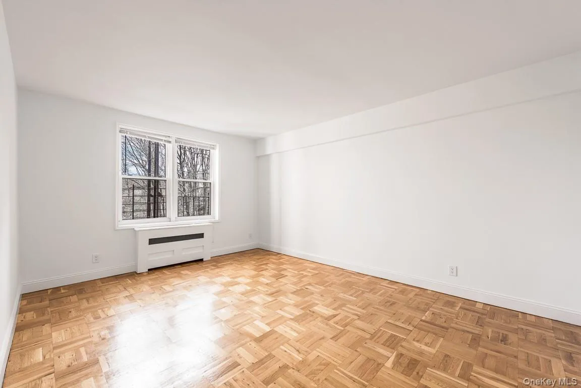 Empty room featuring radiator heating unit and baseboards Empty room featuring radiator heating unit and baseboards