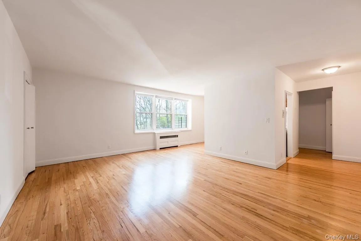 Spare room with light wood-style flooring and baseboards Spare room with light wood-style flooring and baseboards