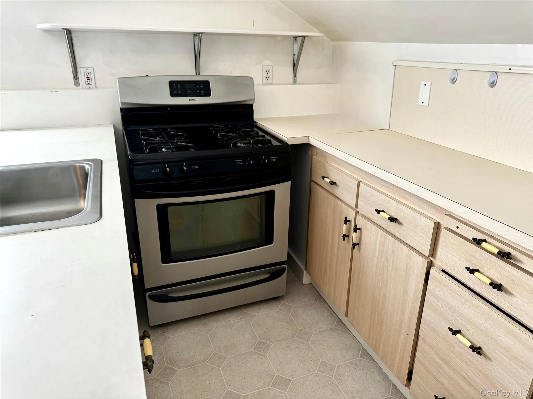 Kitchen with gas stove, and light tile patterned floors Kitchen with gas stove, and light tile patterned floors