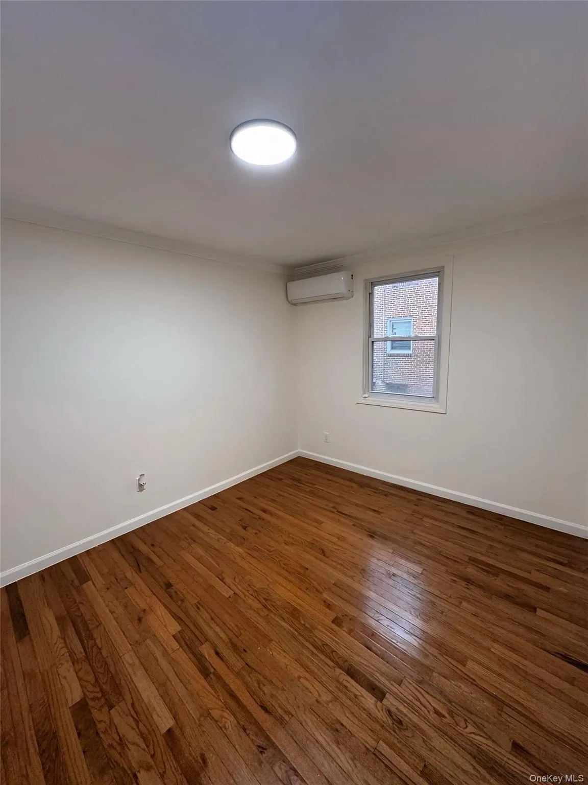 Unfurnished room featuring hardwood / wood-style floors, crown molding, and a wall unit AC Unfurnished room featuring hardwood / wood-style floors, crown molding, and a wall unit AC