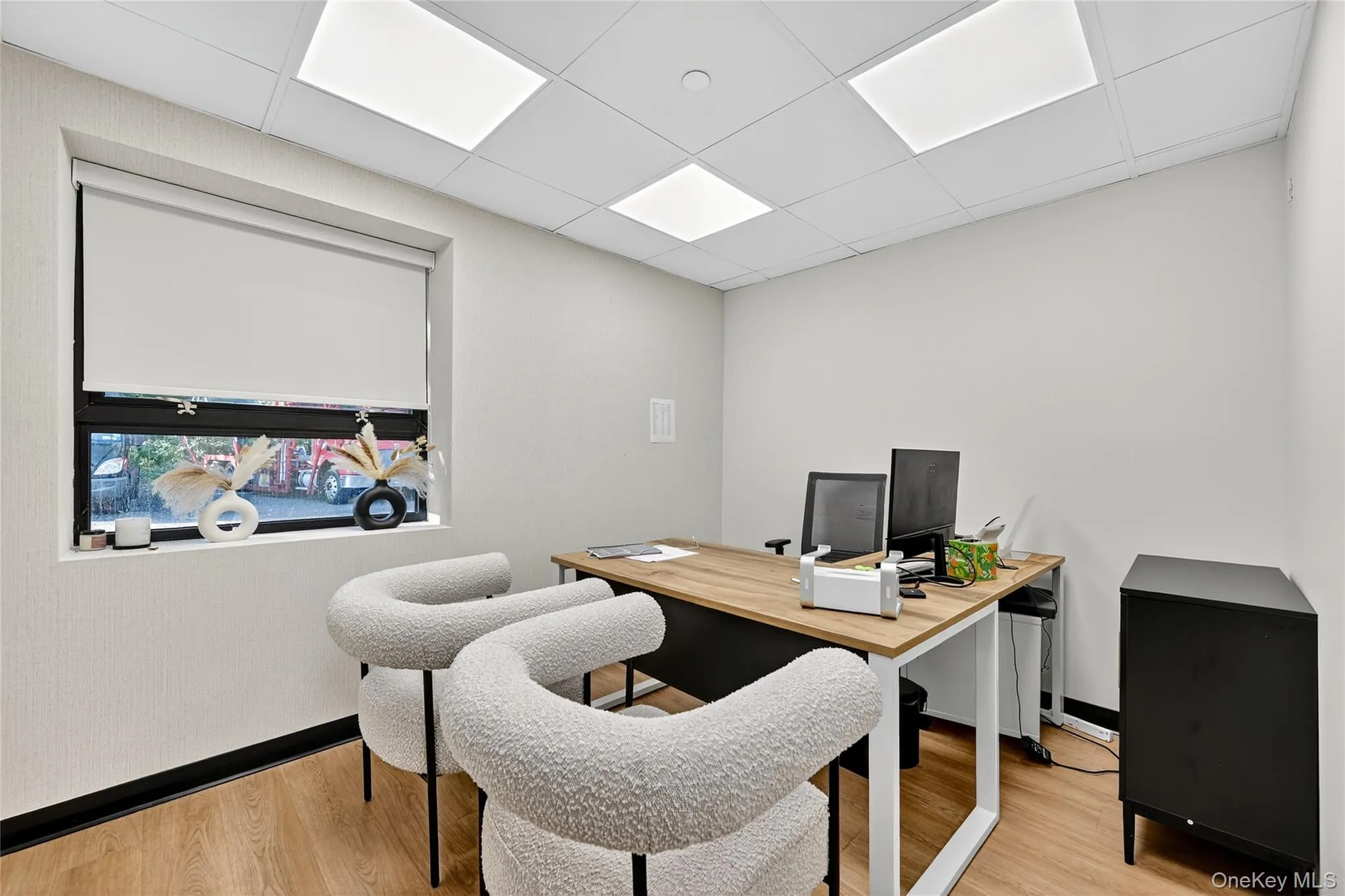 Office featuring light wood-type flooring and a drop ceiling Office featuring light wood-type flooring and a drop ceiling