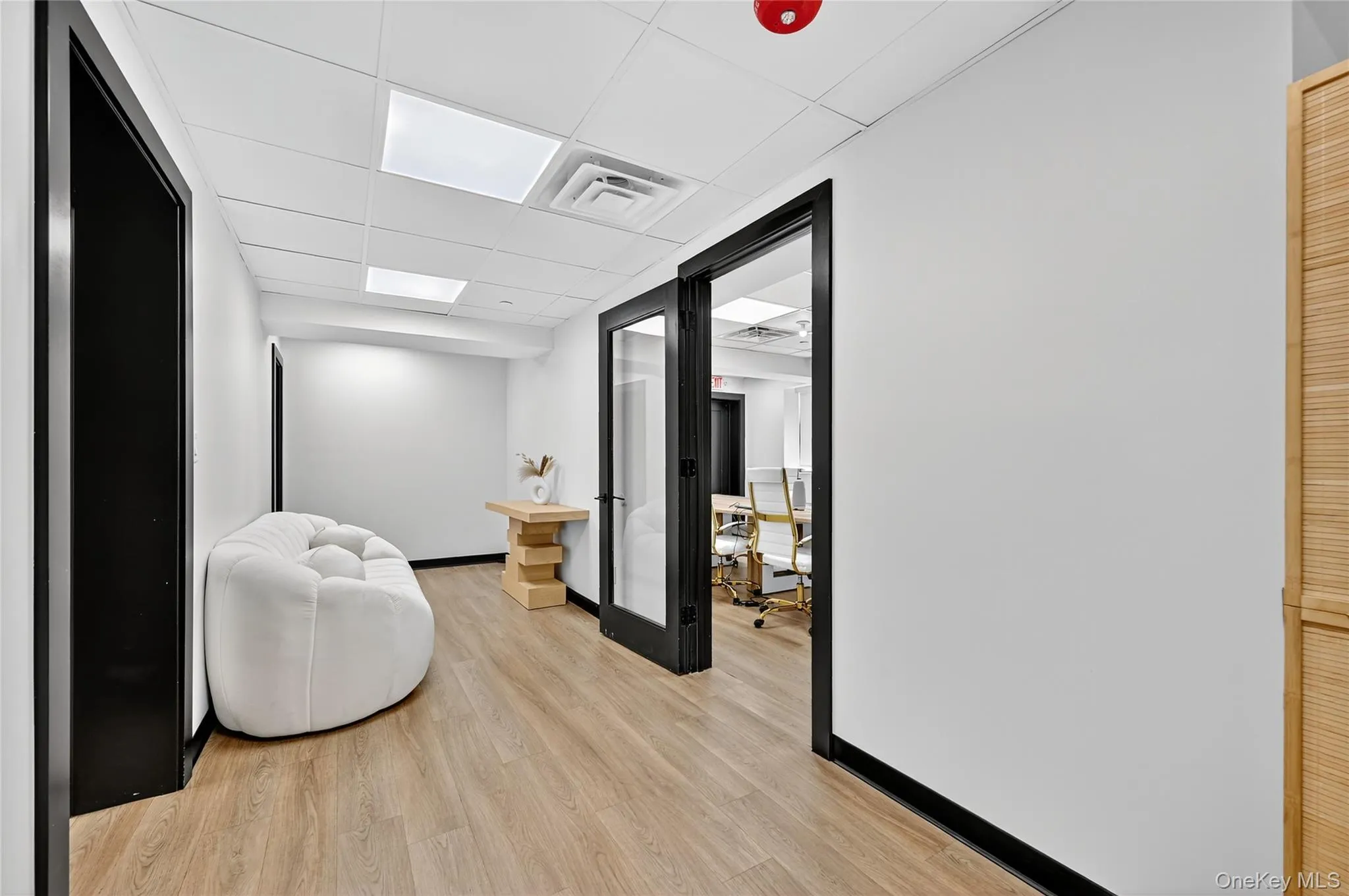 Living area featuring a drop ceiling and a desk Living area featuring a drop ceiling and a desk