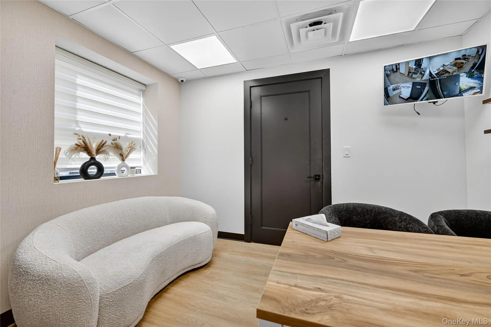 Sitting room with a drop ceiling and wood finished floors Sitting room with a drop ceiling and wood finished floors