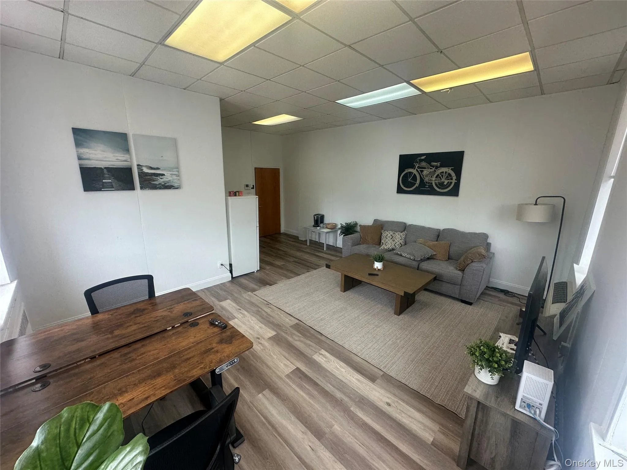 Living room with a drop ceiling and wood finished floors Living room with a drop ceiling and wood finished floors