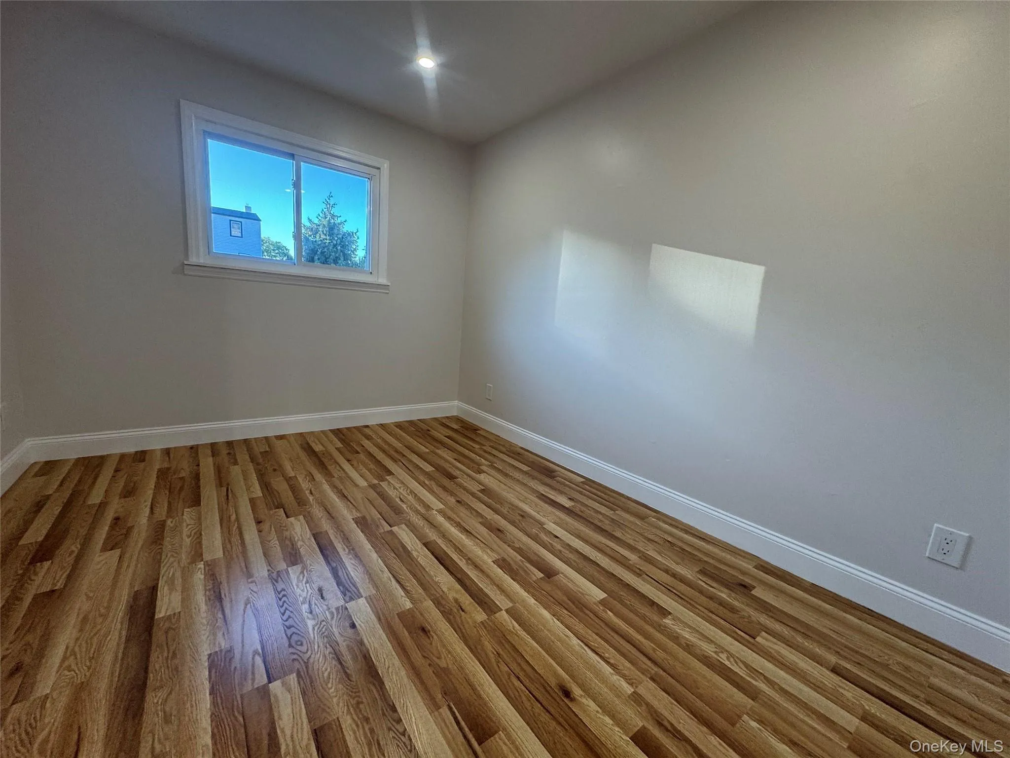 Spare room with baseboards and light wood finished floors Spare room with baseboards and light wood finished floors