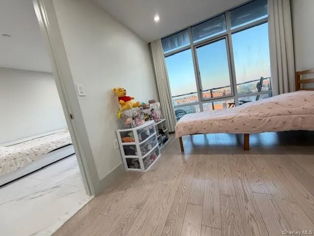 Bedroom with expansive windows and light wood-style floors Bedroom with expansive windows and light wood-style floors