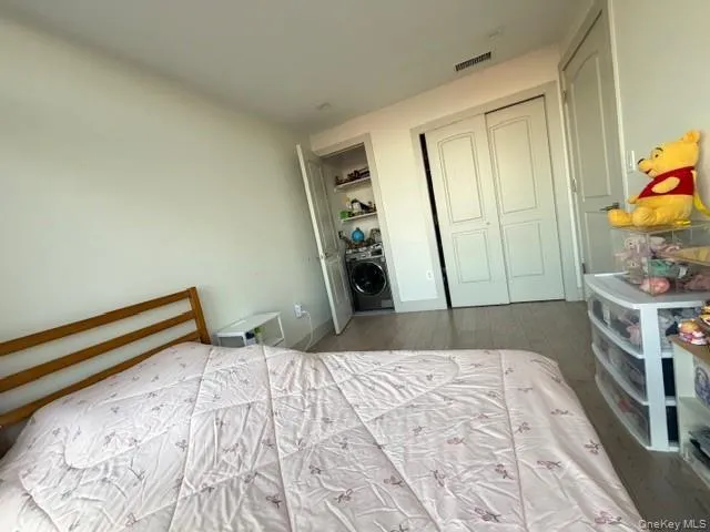 Bedroom featuring hardwood / wood-style floors, washer / dryer, and a closet Bedroom featuring hardwood / wood-style floors, washer / dryer, and a closet