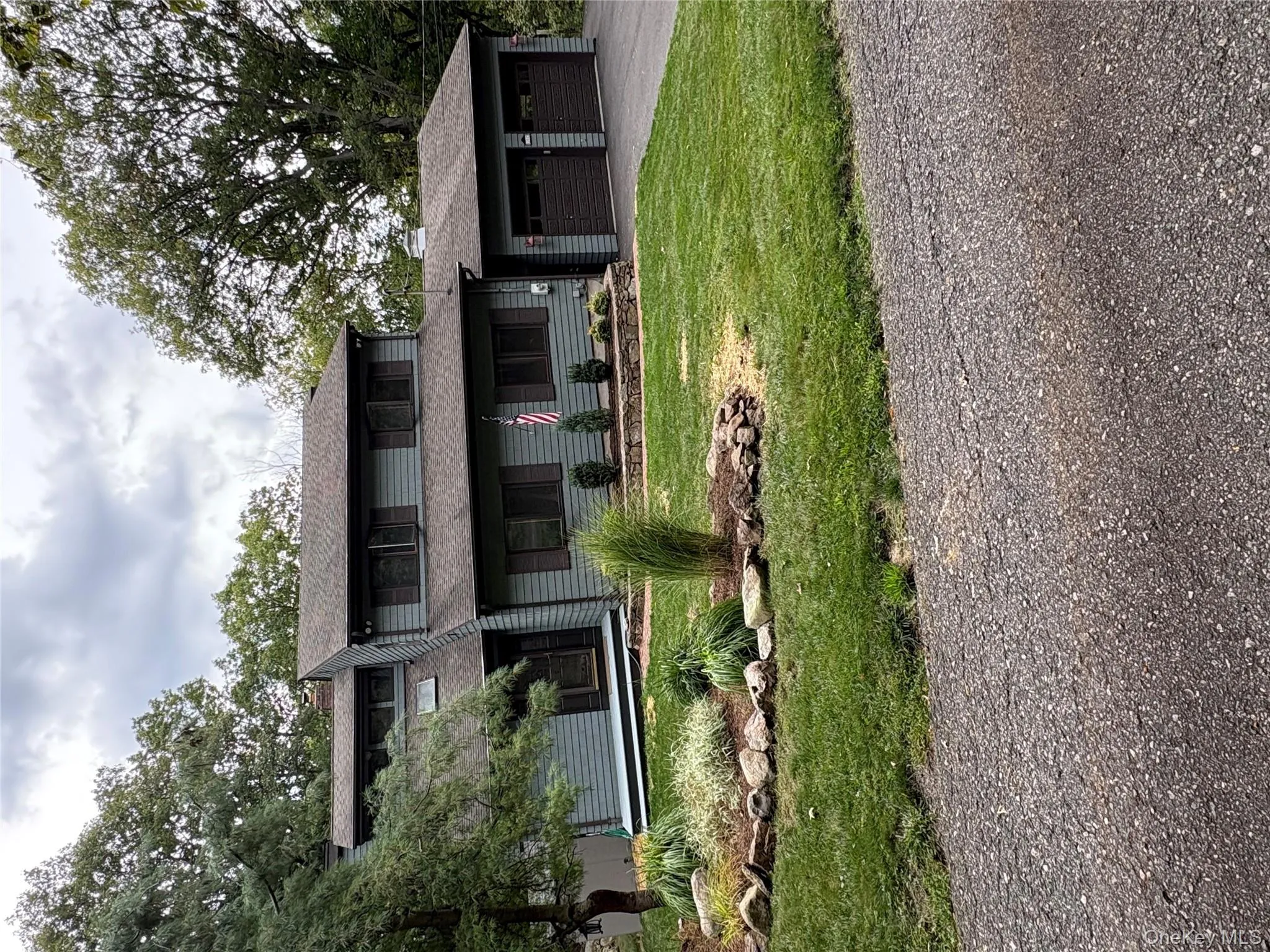 View of front of home with asphalt driveway, an attached garage, a front yard, and a shingled roof View of front of home with asphalt driveway, an attached garage, a front yard, and a shingled roof