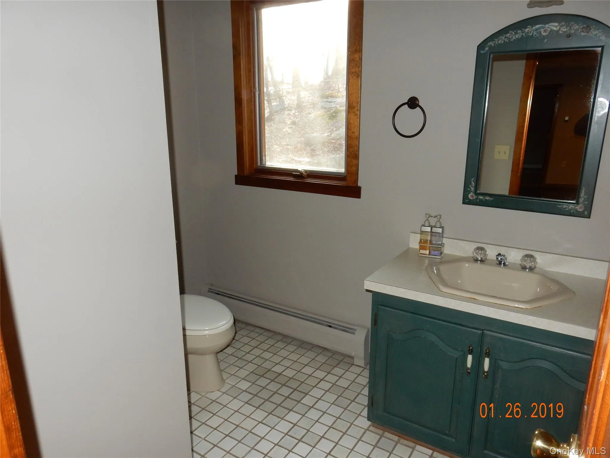 Half bathroom featuring a baseboard heating unit, vanity, and light tile patterned flooring Half bathroom featuring a baseboard heating unit, vanity, and light tile patterned flooring