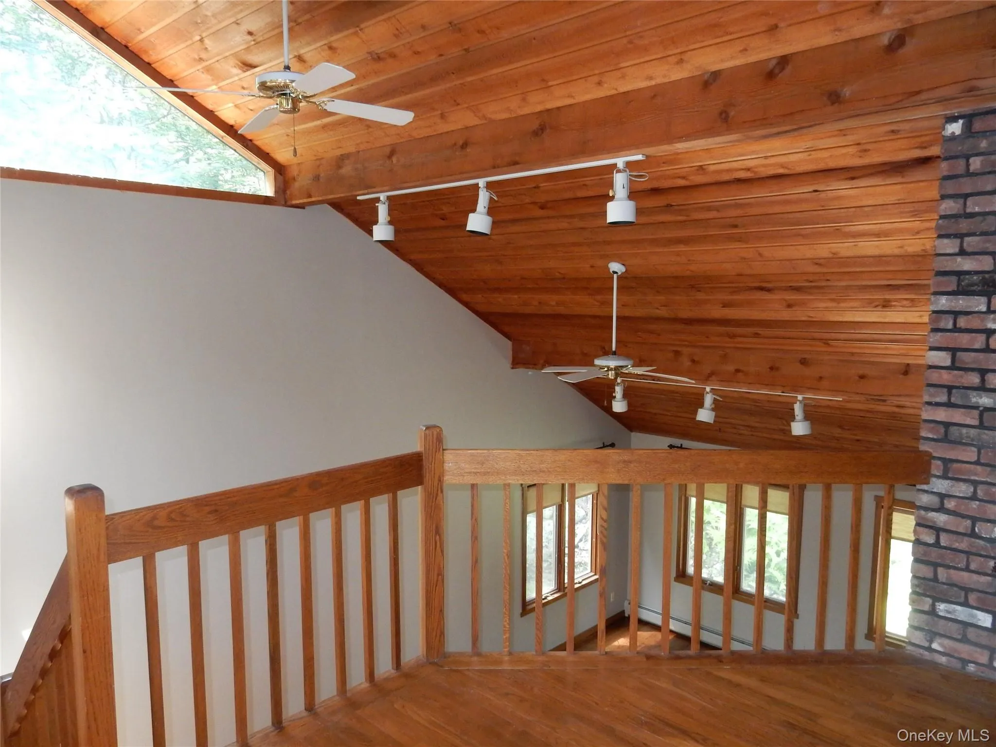Stairway with track lighting, ceiling fan, a wood ceiling with exposed beams, wood finished floors, and a baseboard heating unit Stairway with track lighting, ceiling fan, a wood ceiling with exposed beams, wood finished floors, and a baseboard heating unit