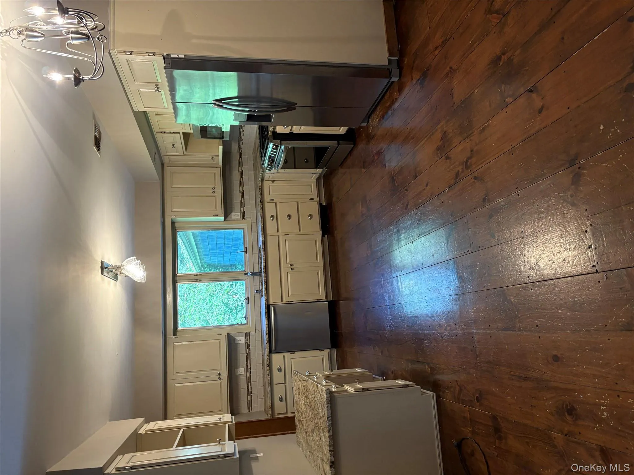 Kitchen with a chandelier, dark wood-style floors, refrigerator, stove, and dishwashing machine Kitchen with a chandelier, dark wood-style floors, refrigerator, stove, and dishwashing machine