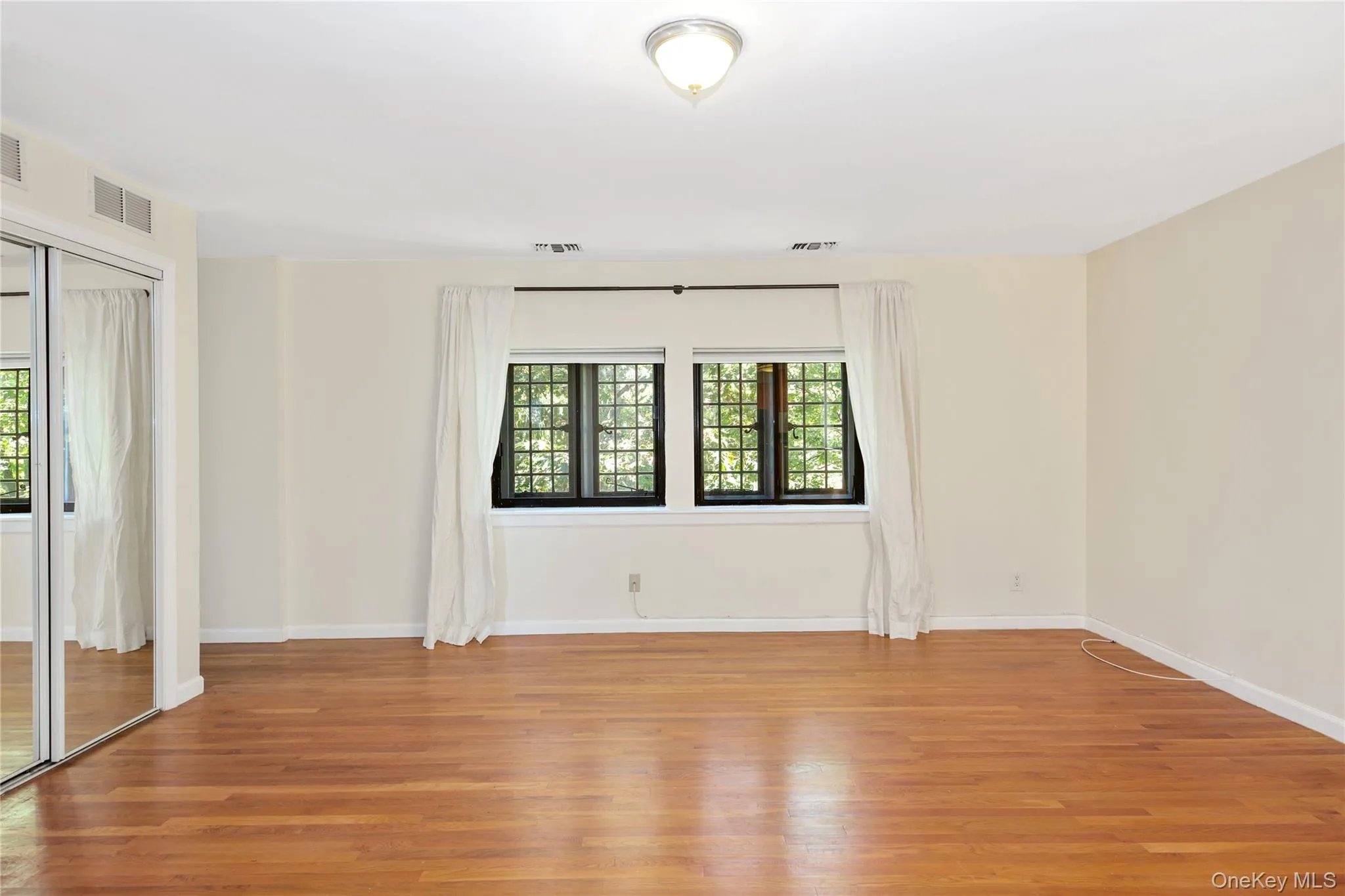 Spare room featuring light wood finished floors and baseboards Spare room featuring light wood finished floors and baseboards