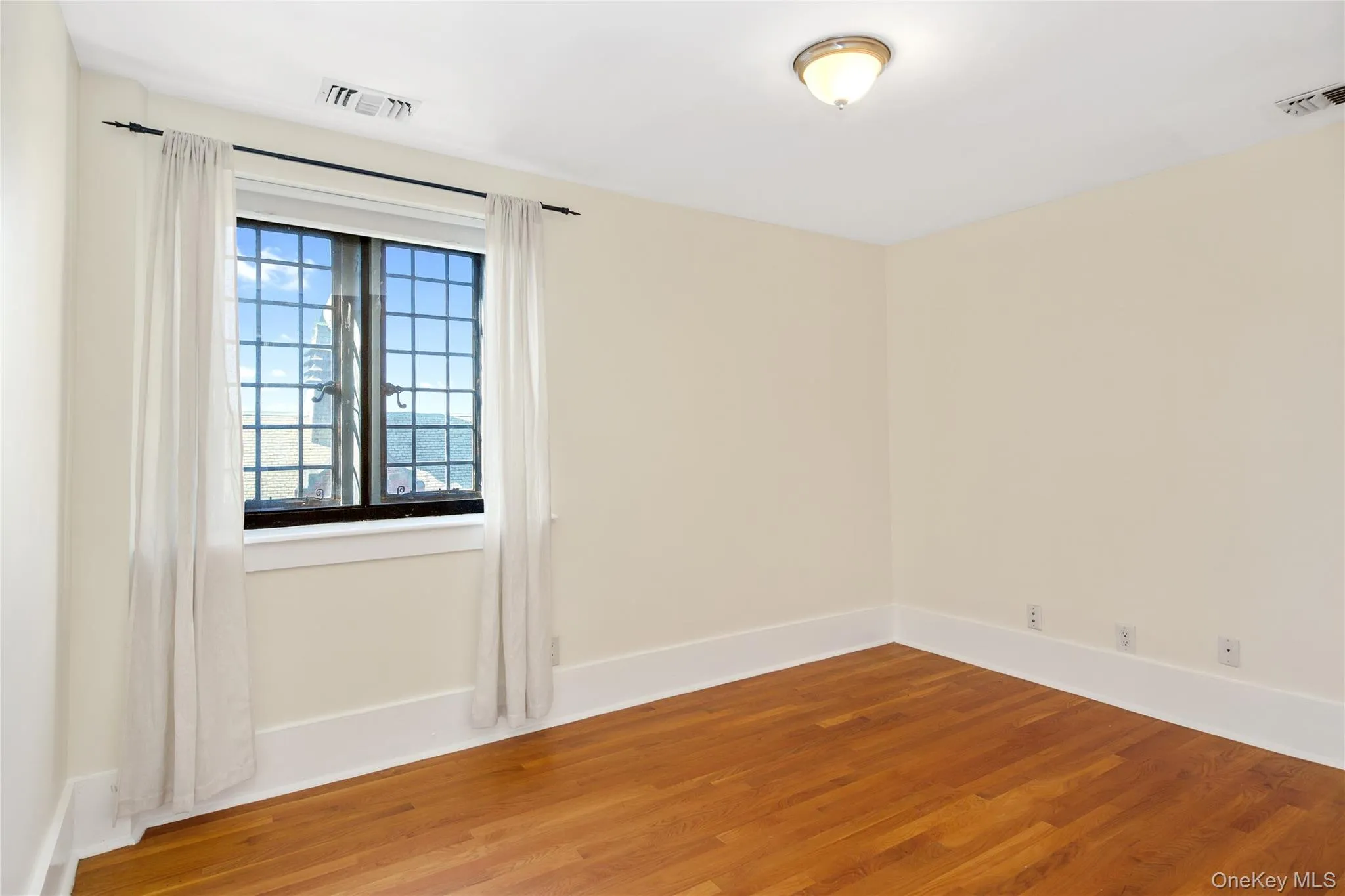 Spare room with wood finished floors and baseboards Spare room with wood finished floors and baseboards