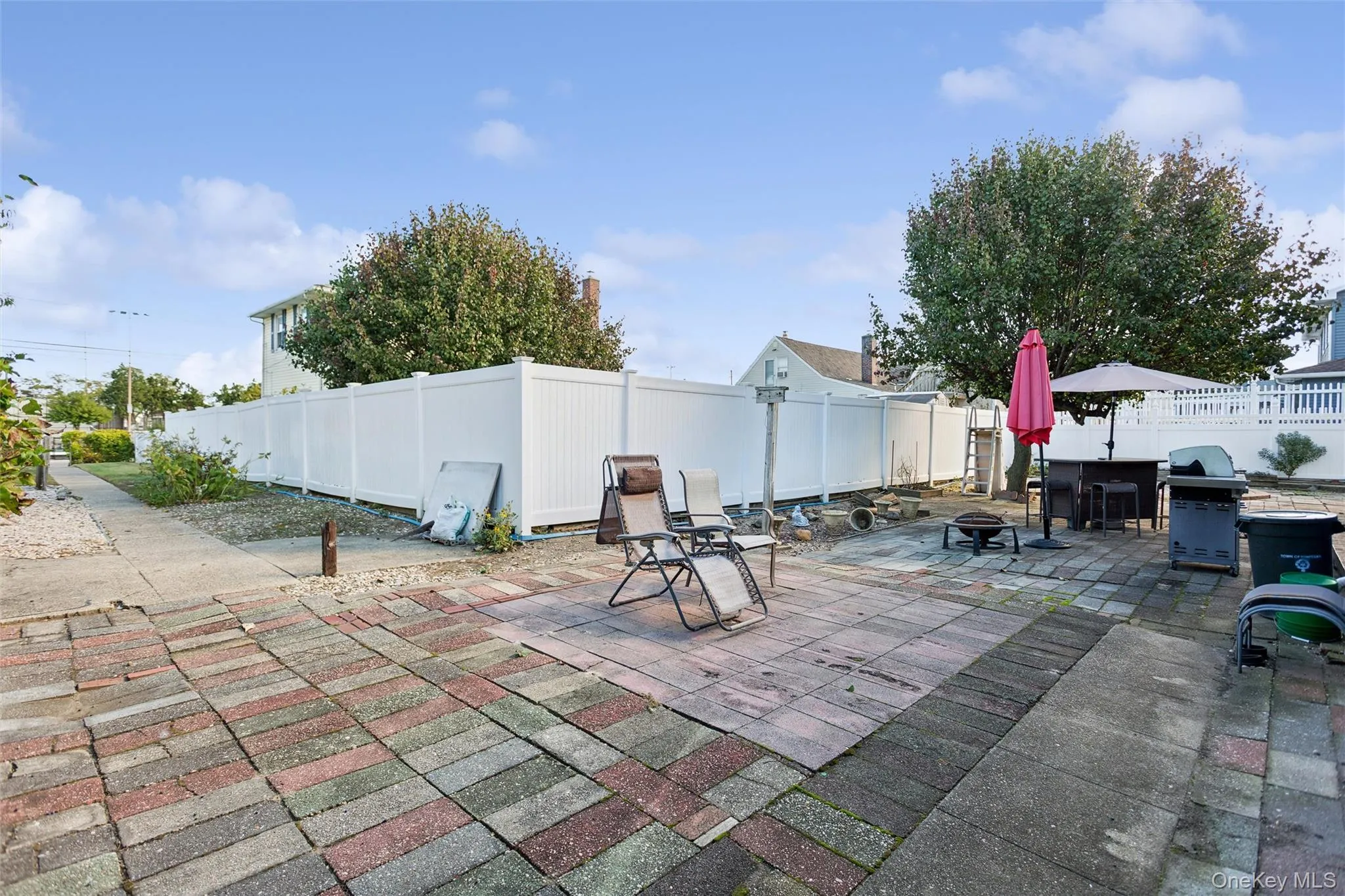 Fenced backyard with a patio area, grilling area, and an outdoor fire pit Fenced backyard with a patio area, grilling area, and an outdoor fire pit