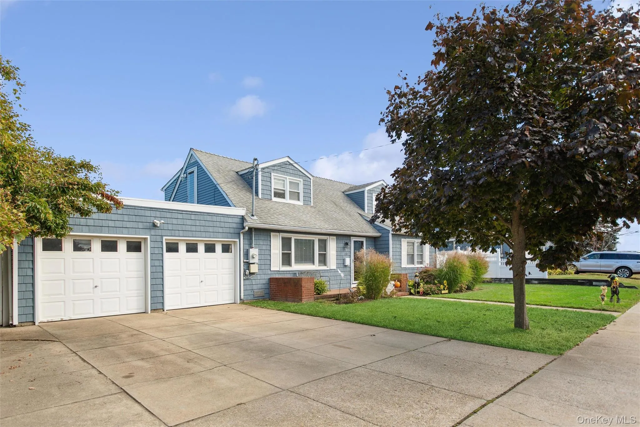 View of front facade with a front lawn, concrete driveway, a garage, and roof with shingles View of front facade with a front lawn, concrete driveway, a garage, and roof with shingles