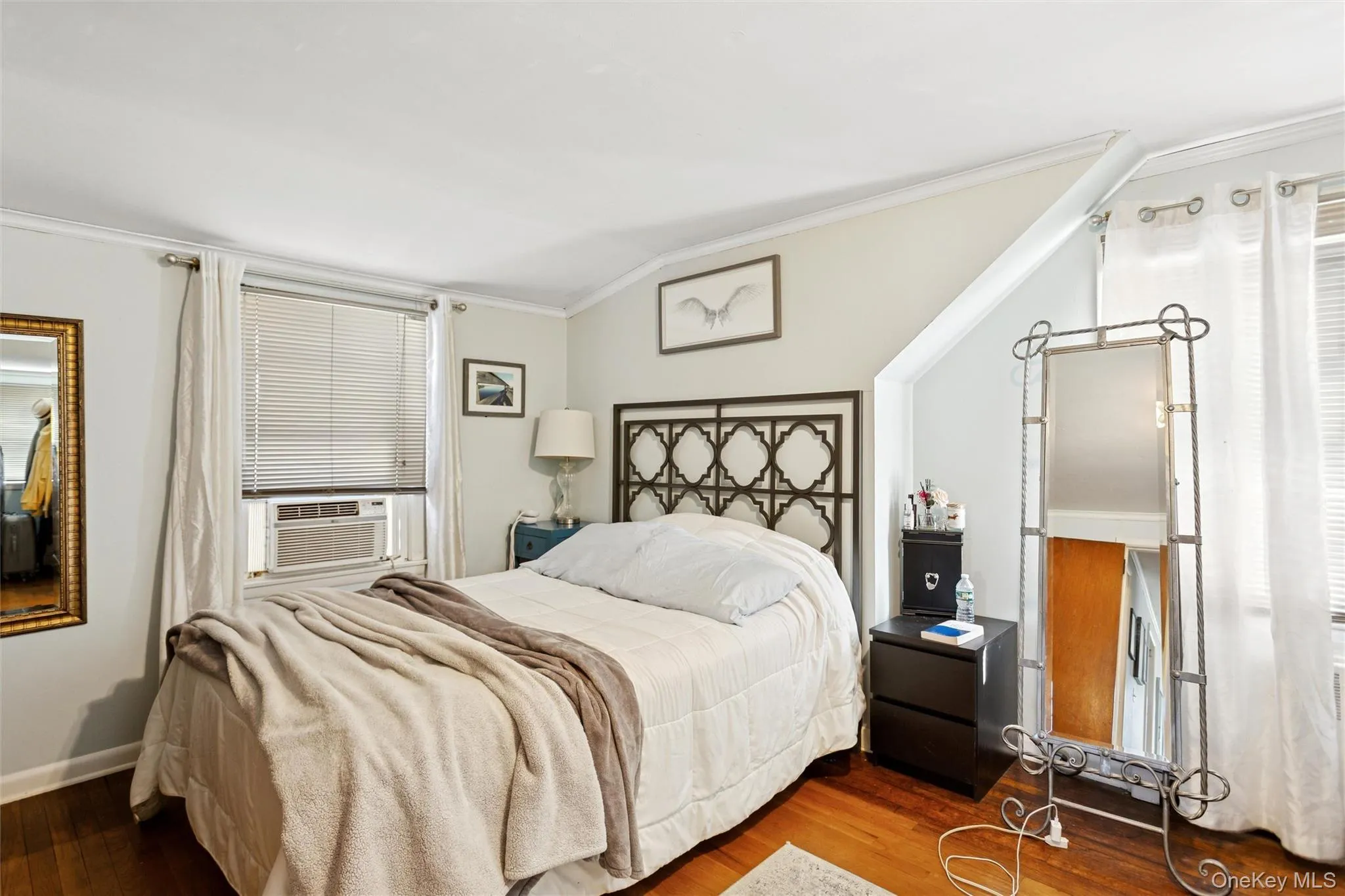 Bedroom with ornamental molding, dark wood-type flooring, cooling unit, and lofted ceiling Bedroom with ornamental molding, dark wood-type flooring, cooling unit, and lofted ceiling
