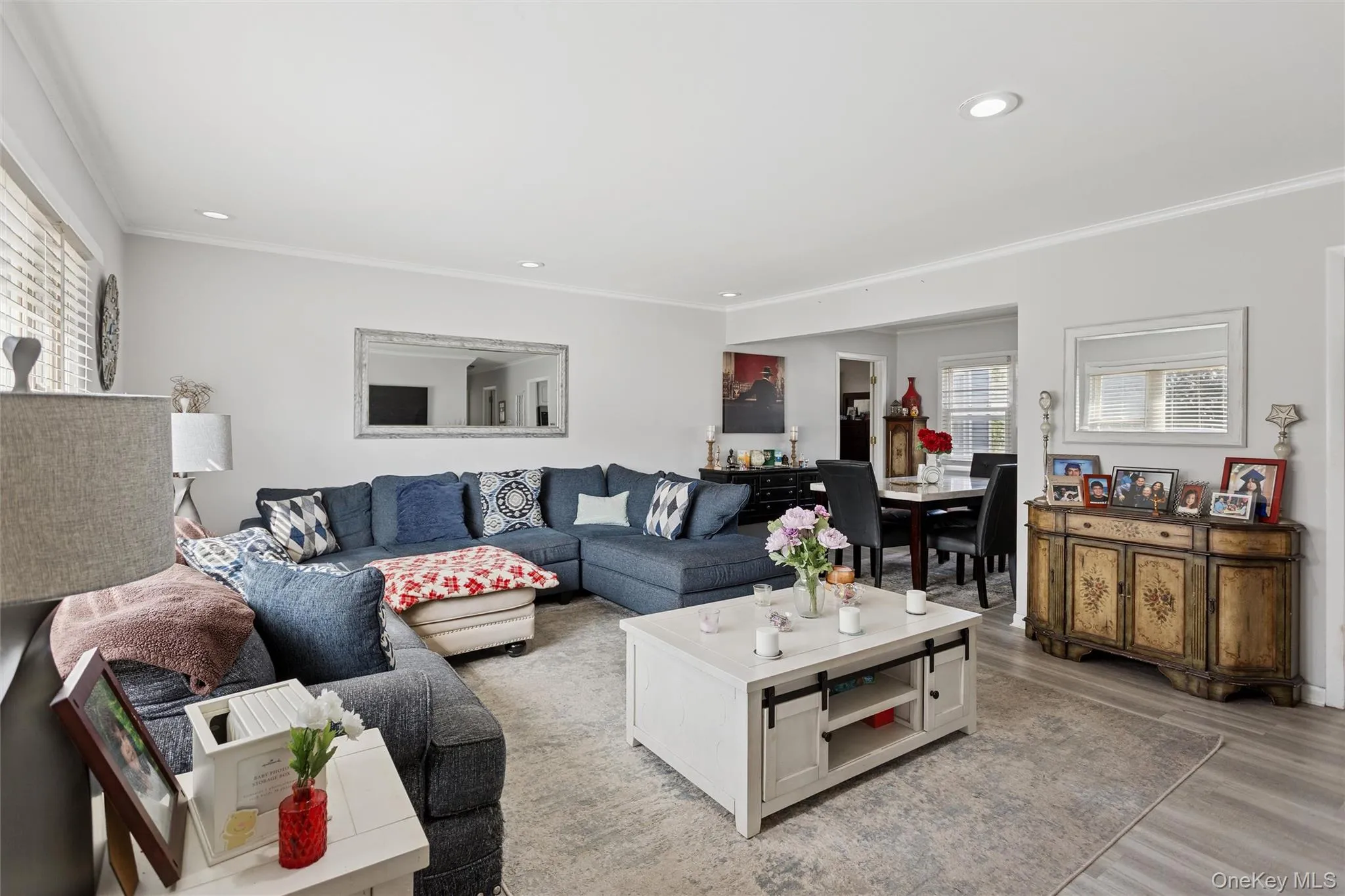 Living room with ornamental molding, light wood-style flooring, and recessed lighting Living room with ornamental molding, light wood-style flooring, and recessed lighting