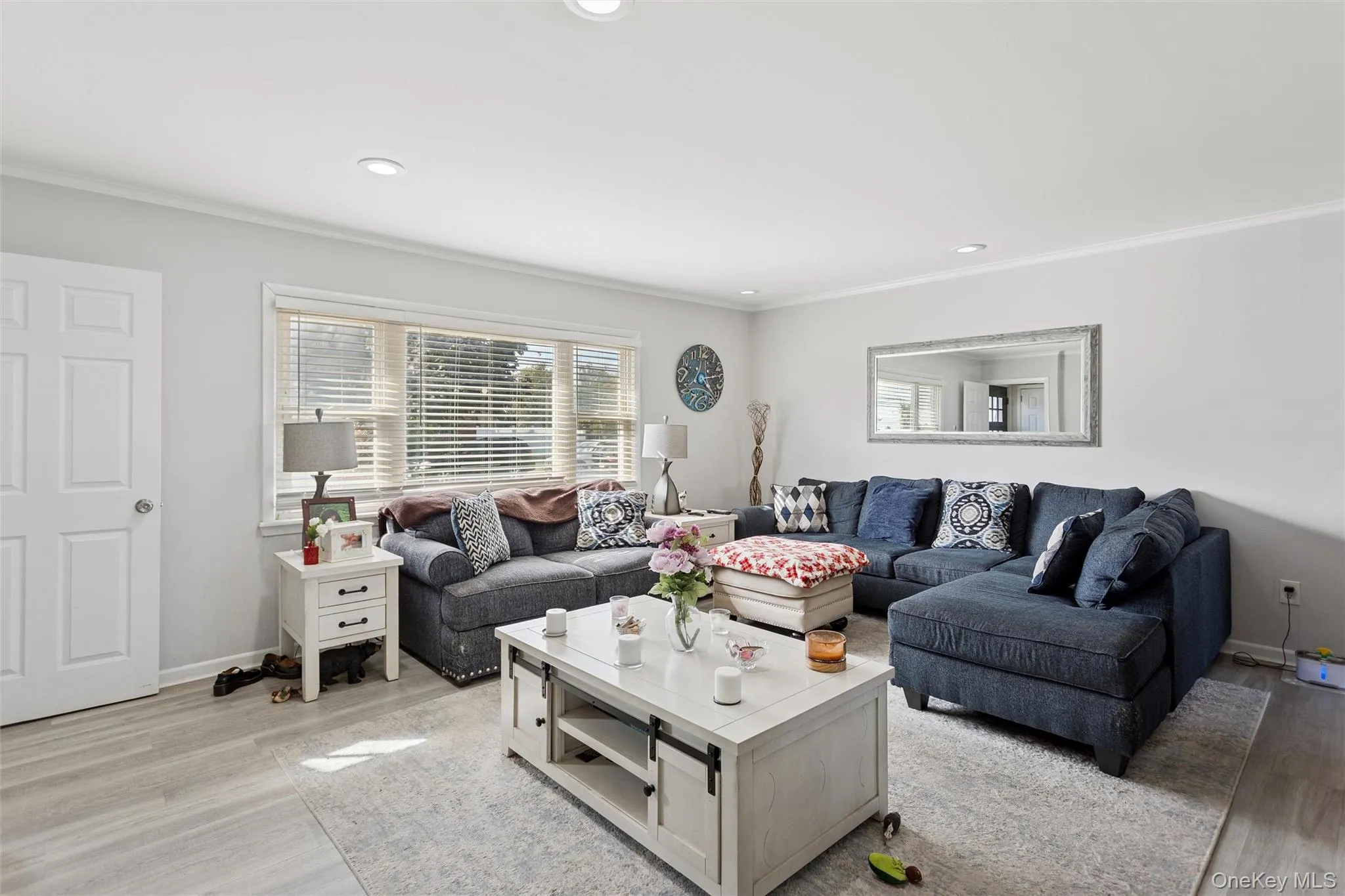 Living area with light wood-style flooring, recessed lighting, and crown molding Living area with light wood-style flooring, recessed lighting, and crown molding