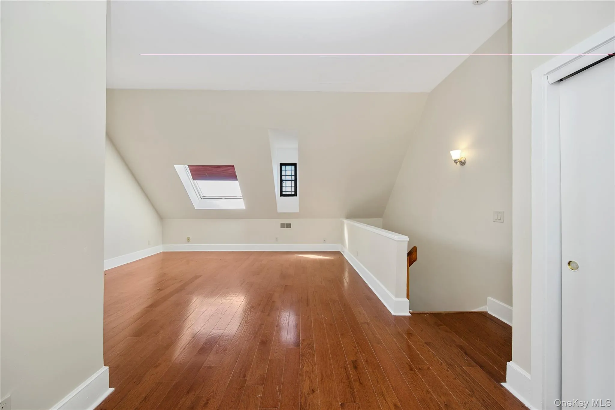 Bonus room with a skylight, hardwood / wood-style floors, and lofted ceiling Bonus room with a skylight, hardwood / wood-style floors, and lofted ceiling