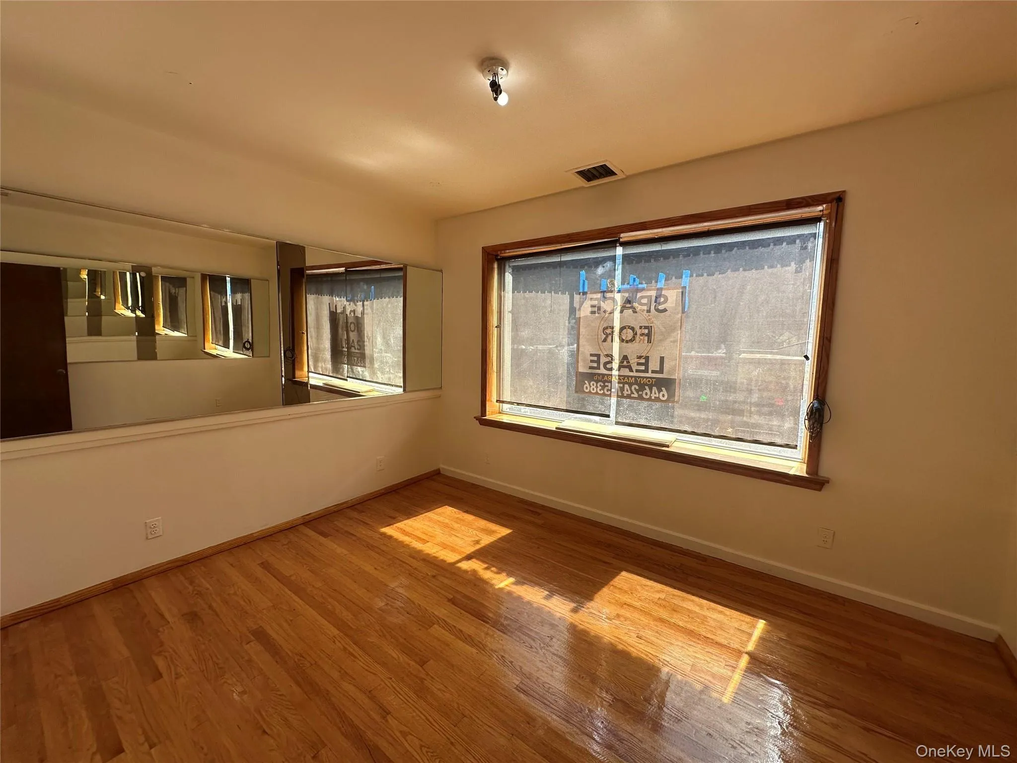 Spare room featuring baseboards and wood finished floors Spare room featuring baseboards and wood finished floors