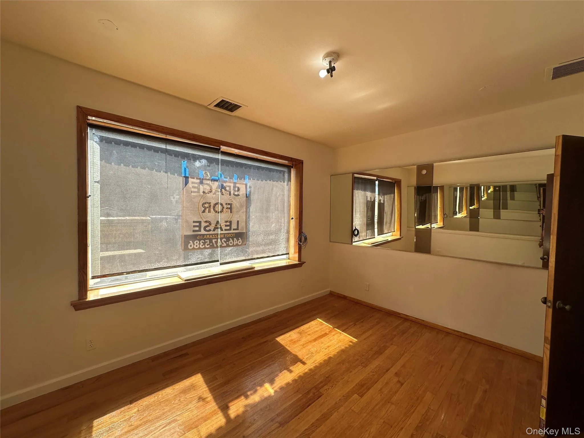 Spare room featuring light wood-style floors and stairs Spare room featuring light wood-style floors and stairs
