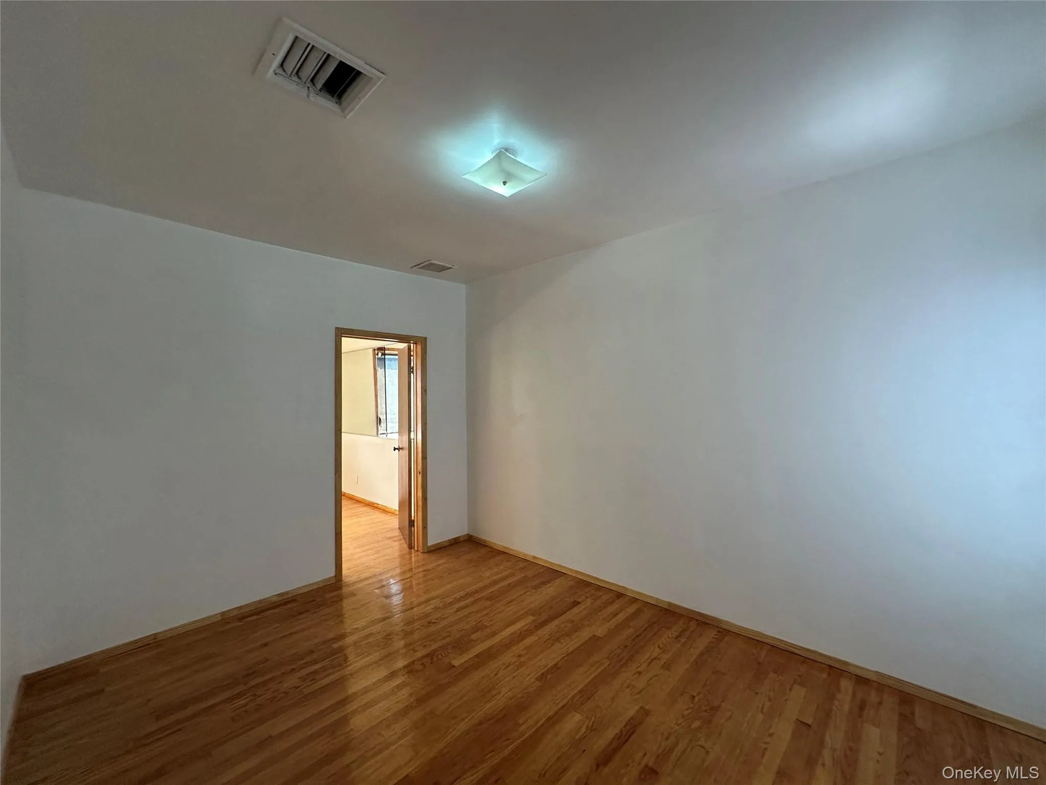 Empty room with wood finished floors and baseboards Empty room with wood finished floors and baseboards